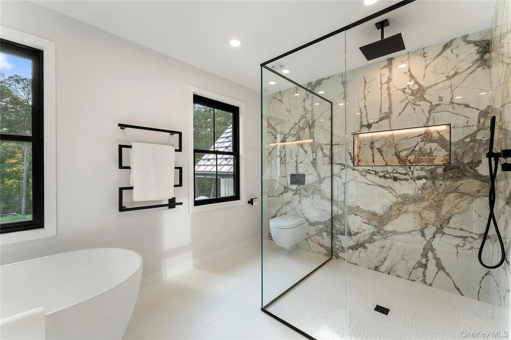 Full bath with a marble finish shower, a freestanding tub, recessed lighting, and tile patterned floors Full bath with a marble finish shower, a freestanding tub, recessed lighting, and tile patterned floors