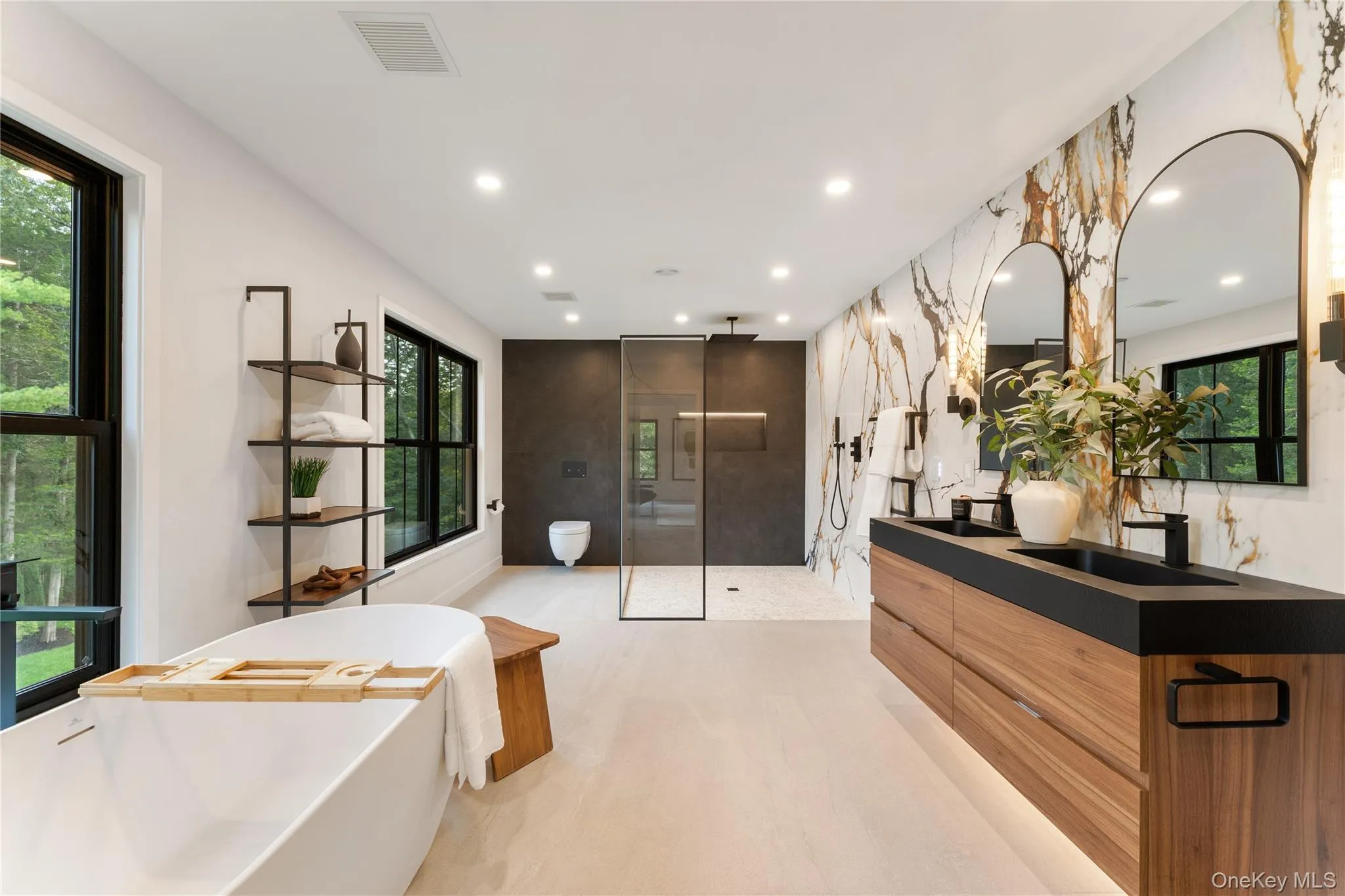 Full bath featuring a walk in shower, double vanity, a freestanding bath, and recessed lighting Full bath featuring a walk in shower, double vanity, a freestanding bath, and recessed lighting