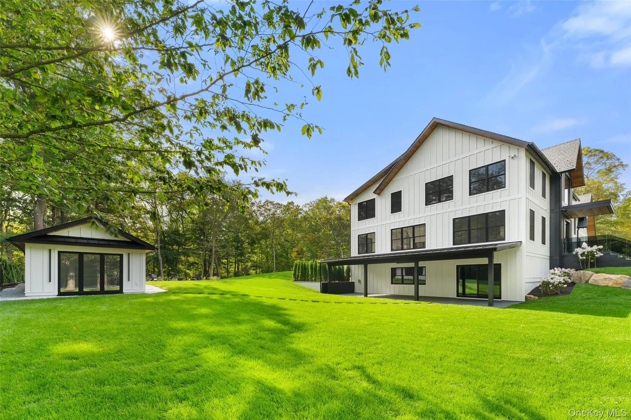 Back of property featuring board and batten siding and a yard Back of property featuring board and batten siding and a yard