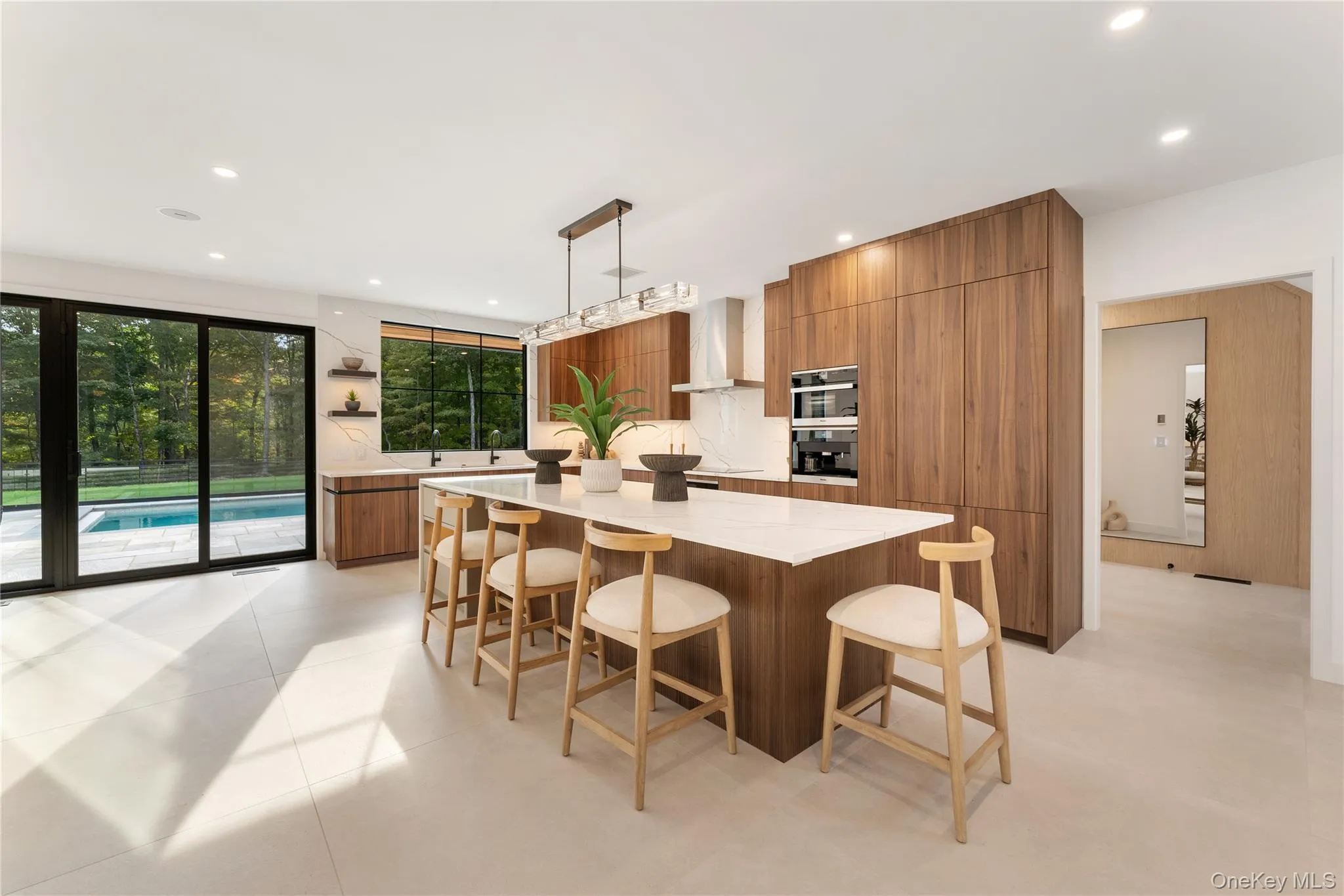 Kitchen featuring modern cabinets, brown cabinets, a breakfast bar area, decorative light fixtures, and a center island Kitchen featuring modern cabinets, brown cabinets, a breakfast bar area, decorative light fixtures, and a center island