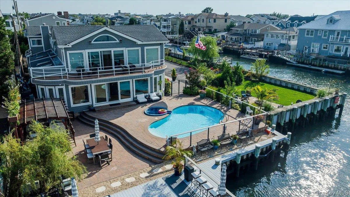 Rear view of house with a water view, a patio, a residential view, a fenced backyard, and a gate Rear view of house with a water view, a patio, a residential view, a fenced backyard, and a gate