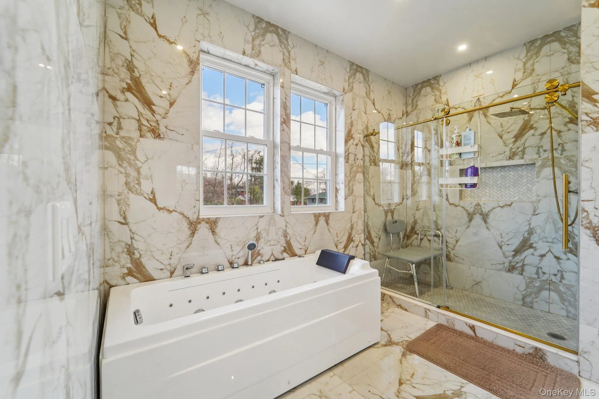This luxurious bathroom features a spacious soaking tub with a shower head, and a separate glass-enclosed shower with gold-toned fixtures. This luxurious bathroom features a spacious soaking tub with a shower head, and a separate glass-enclosed shower with gold-toned fixtures.
