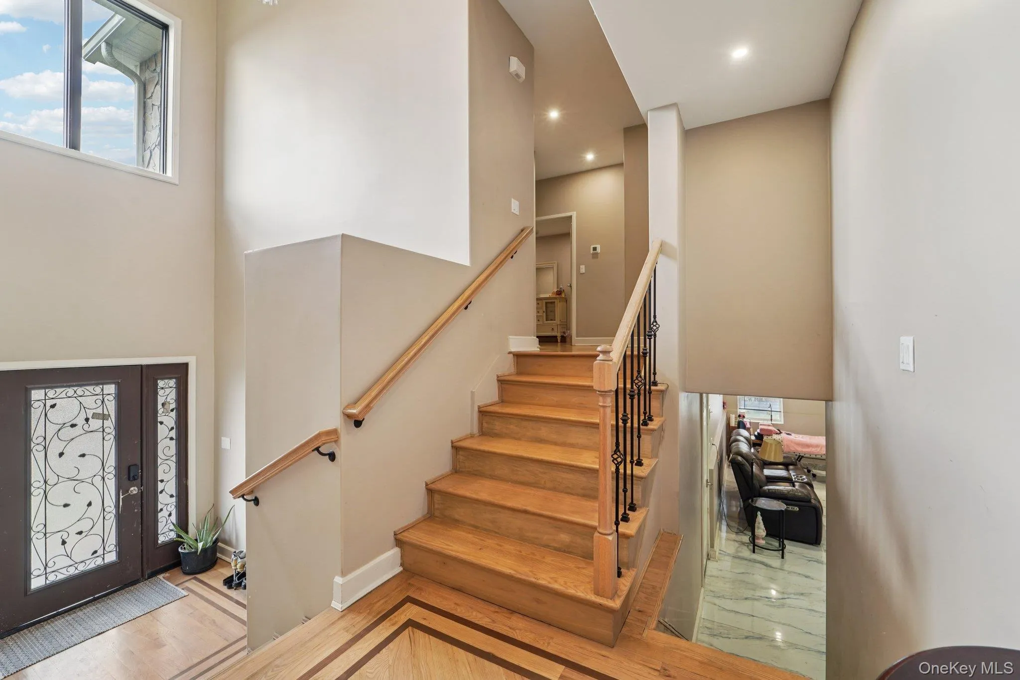The property features a grand entryway with a double door entry, a large window, and a staircase with a wooden handrail and wrought iron spindles. The property features a grand entryway with a double door entry, a large window, and a staircase with a wooden handrail and wrought iron spindles.