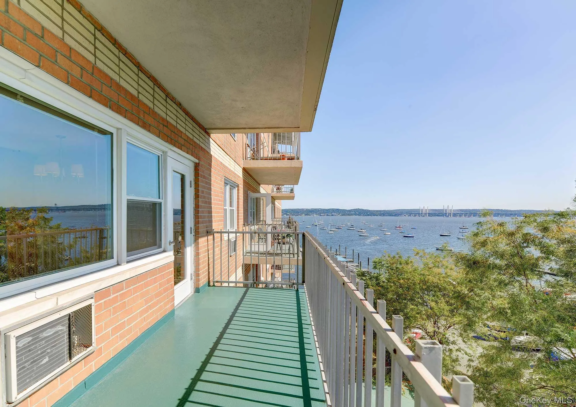The property includes a private balcony with a painted green floor and white railings with river views The property includes a private balcony with a painted green floor and white railings with river views