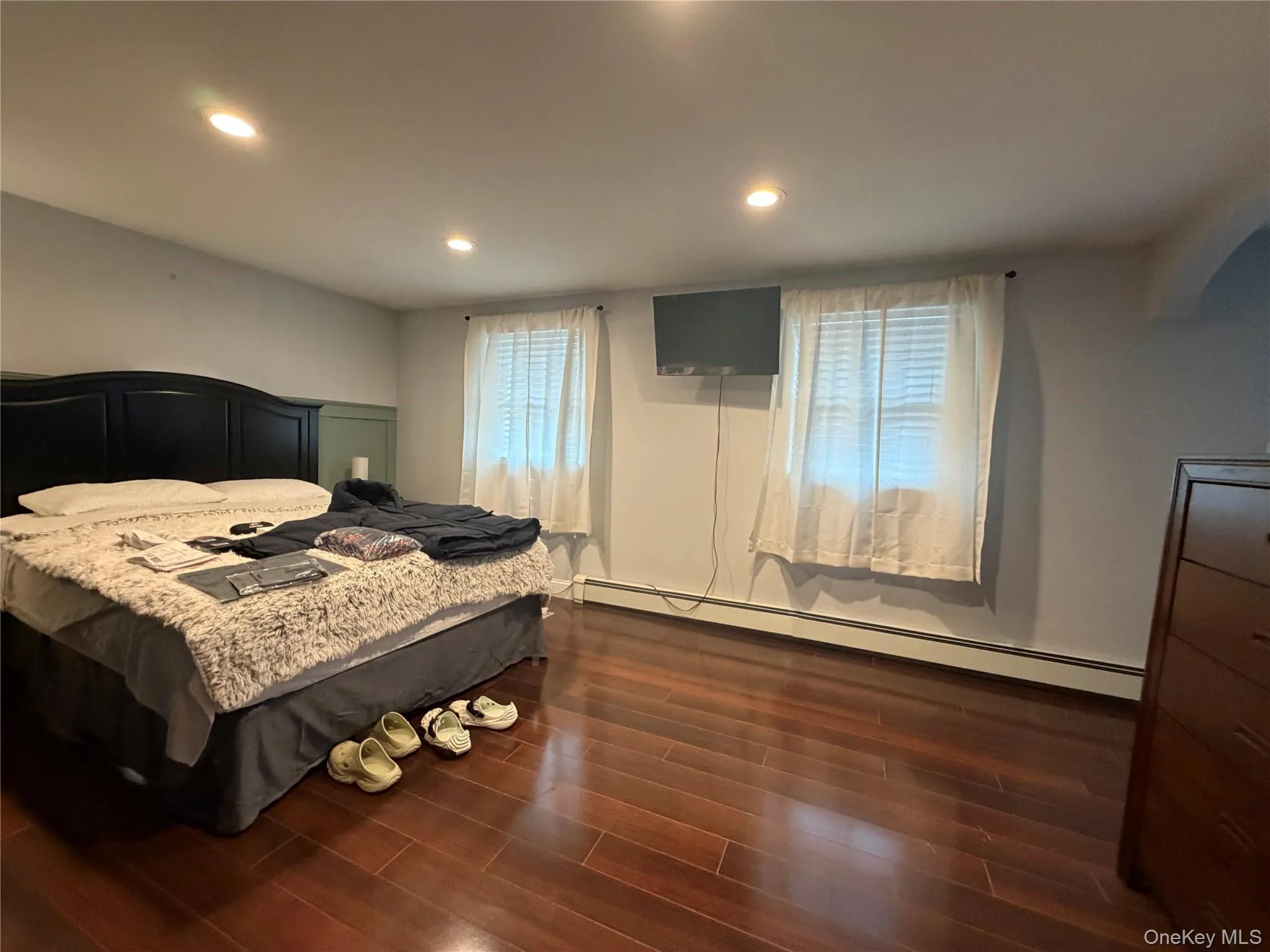 This room features rich hardwood flooring, recessed lighting, and two windows with blinds This room features rich hardwood flooring, recessed lighting, and two windows with blinds