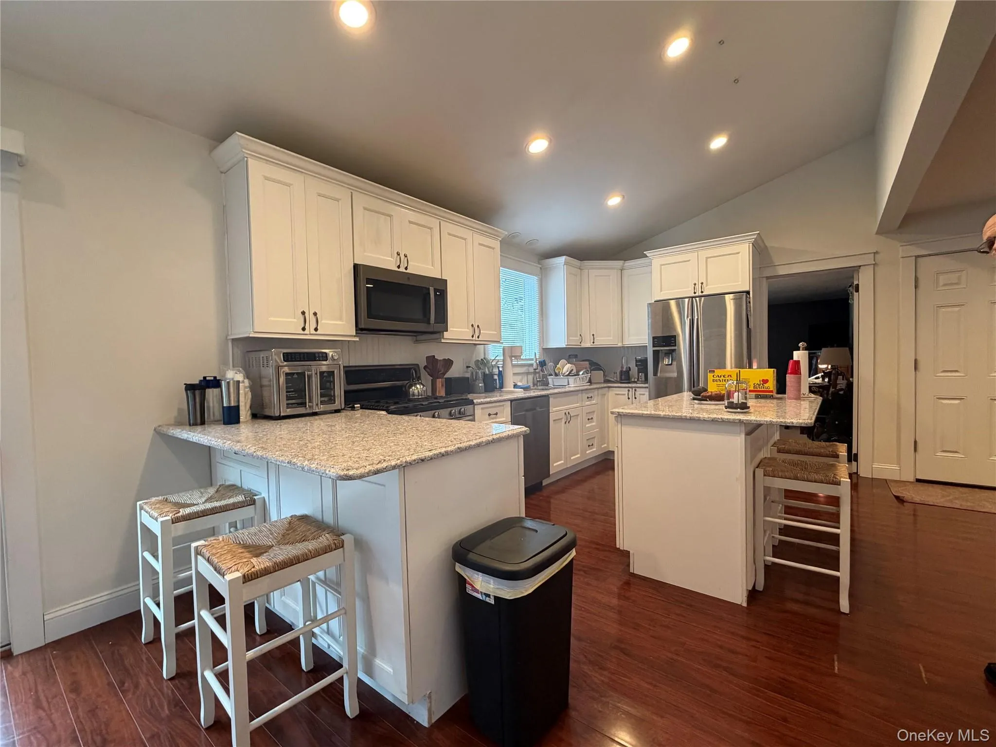 The kitchen features white cabinetry, granite countertops, and stainless steel appliances The kitchen features white cabinetry, granite countertops, and stainless steel appliances