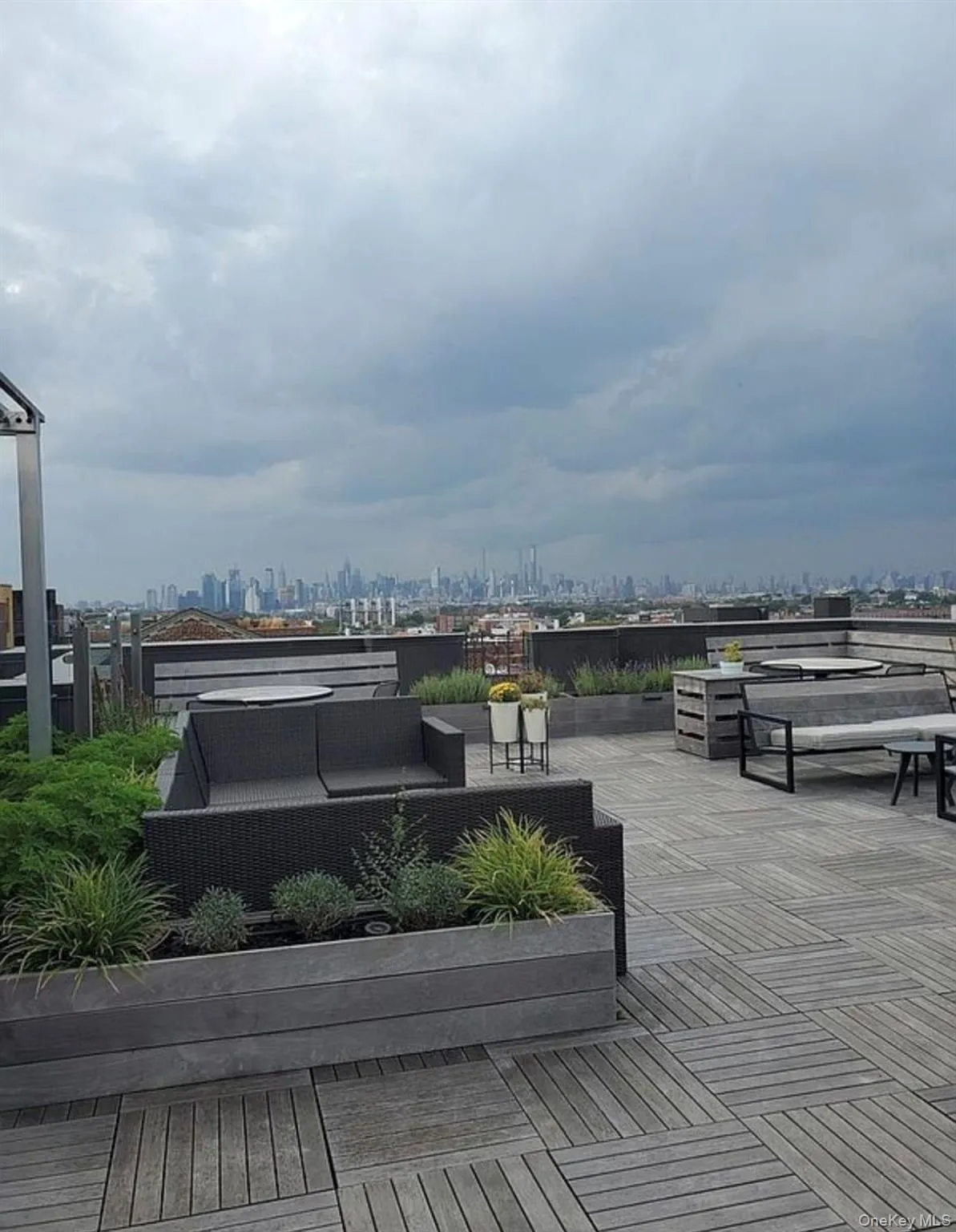 Rooftop terrace with wooden deck flooring, integrated planters, and panoramic skyline views Rooftop terrace with wooden deck flooring, integrated planters, and panoramic skyline views