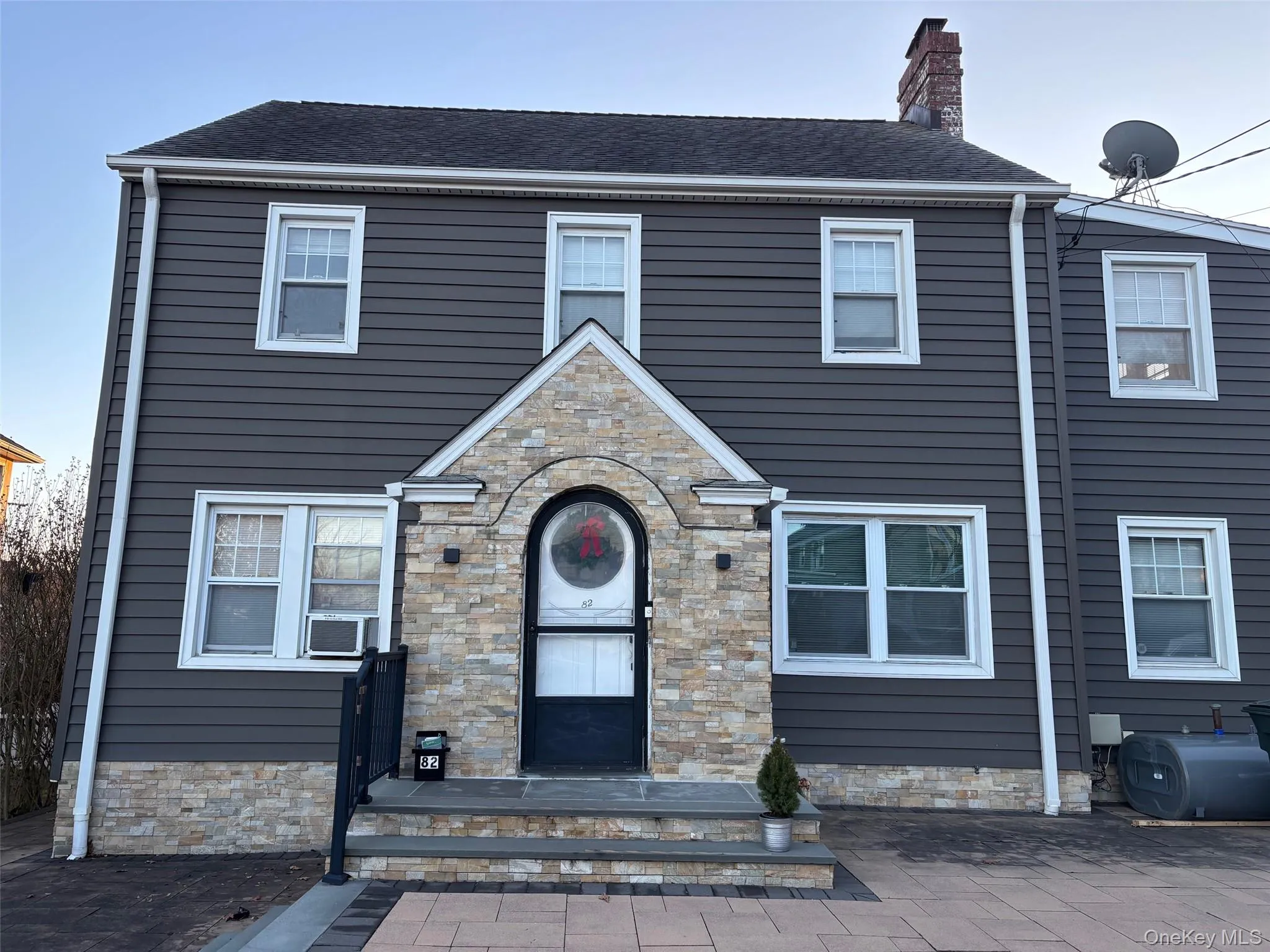 The property features dark gray siding and a stone-clad entranceway The property features dark gray siding and a stone-clad entranceway