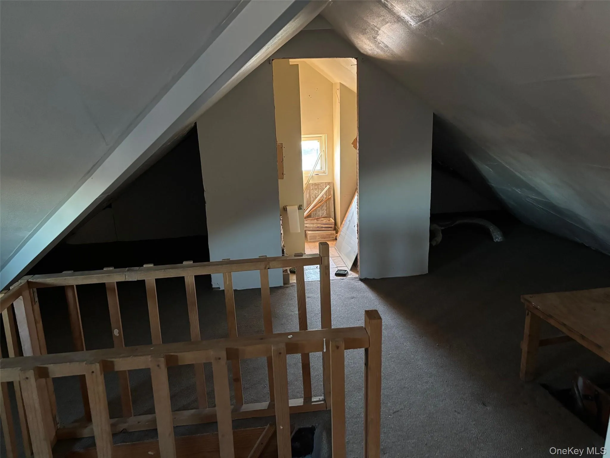 This property features an attic space with sloped ceilings and carpeted flooring This property features an attic space with sloped ceilings and carpeted flooring
