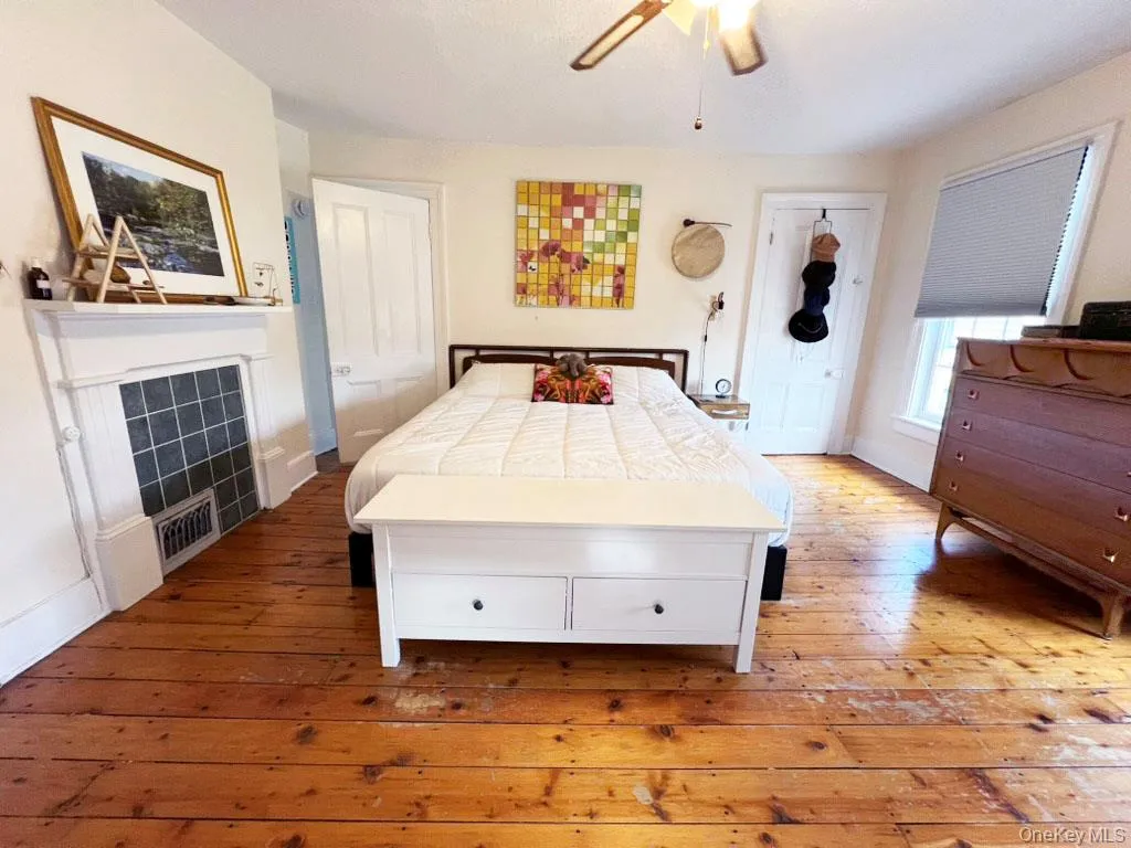 Bedroom featuring wood-type flooring and ceiling fan Bedroom featuring wood-type flooring and ceiling fan