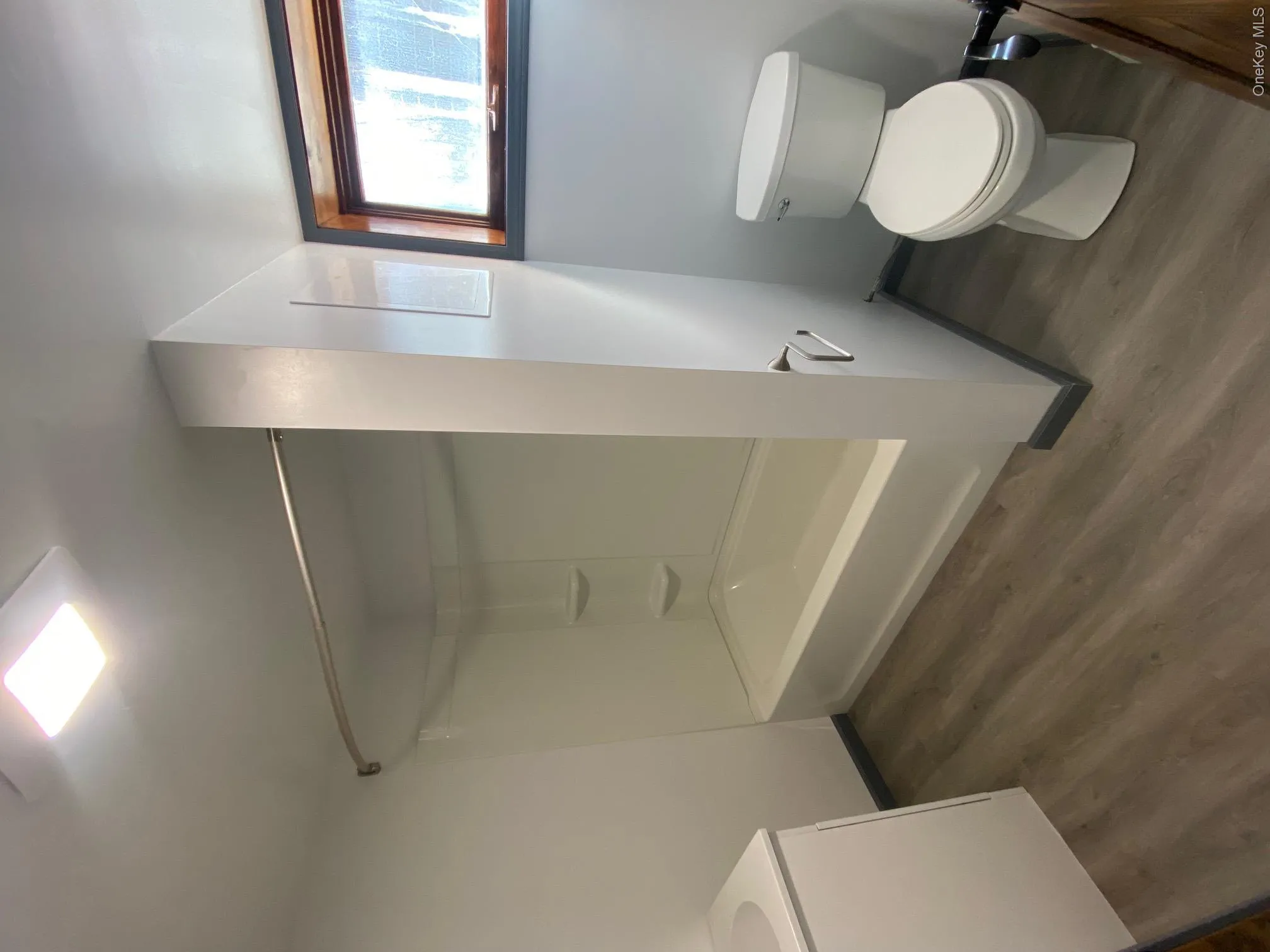 Full bathroom with hardwood / wood-style flooring, vanity, toilet, and tub / shower combination Full bathroom with hardwood / wood-style flooring, vanity, toilet, and tub / shower combination