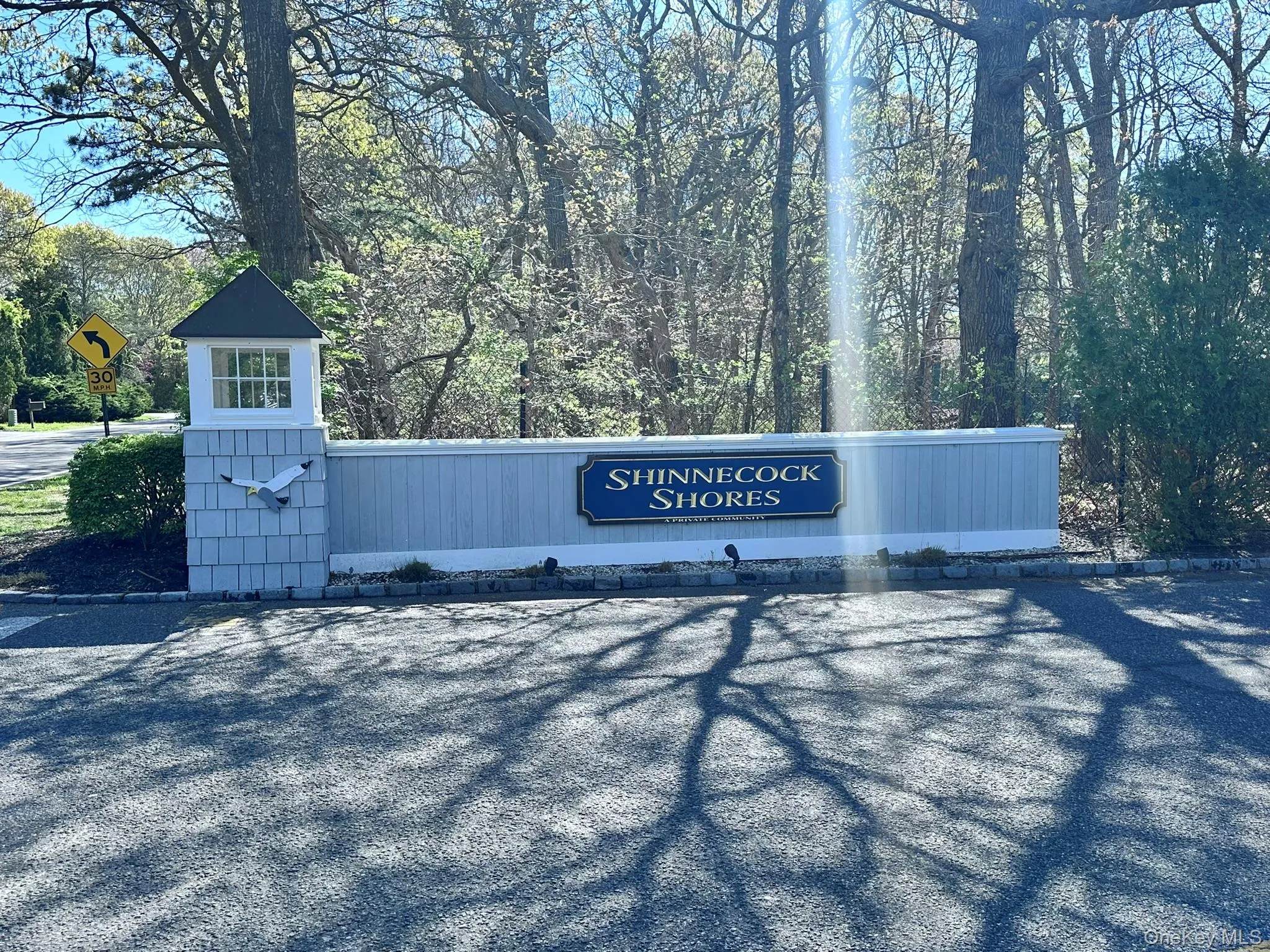 Entrance to Shinnecock Shores, featuring a sign with decorative shingle siding and a cupola Entrance to Shinnecock Shores, featuring a sign with decorative shingle siding and a cupola