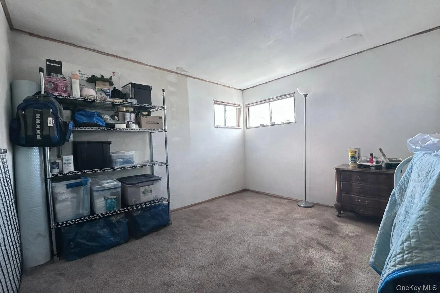 This room features light-colored walls and carpeting, with a window providing natural light This room features light-colored walls and carpeting, with a window providing natural light