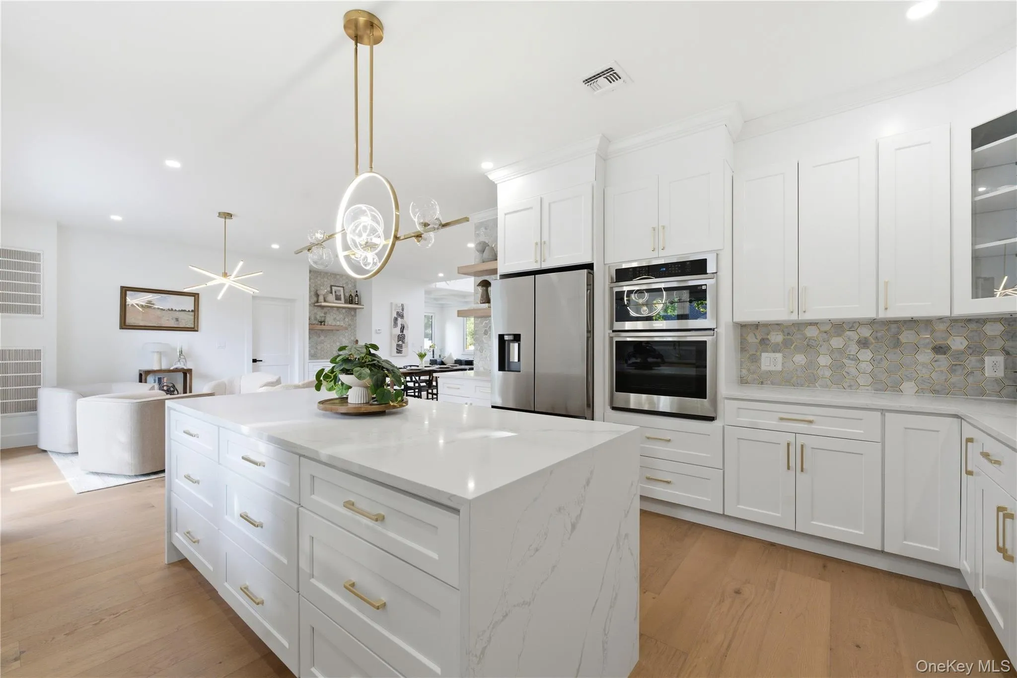 Spacious kitchen featuring an expansive island with white cabinetry and light-toned countertops Spacious kitchen featuring an expansive island with white cabinetry and light-toned countertops