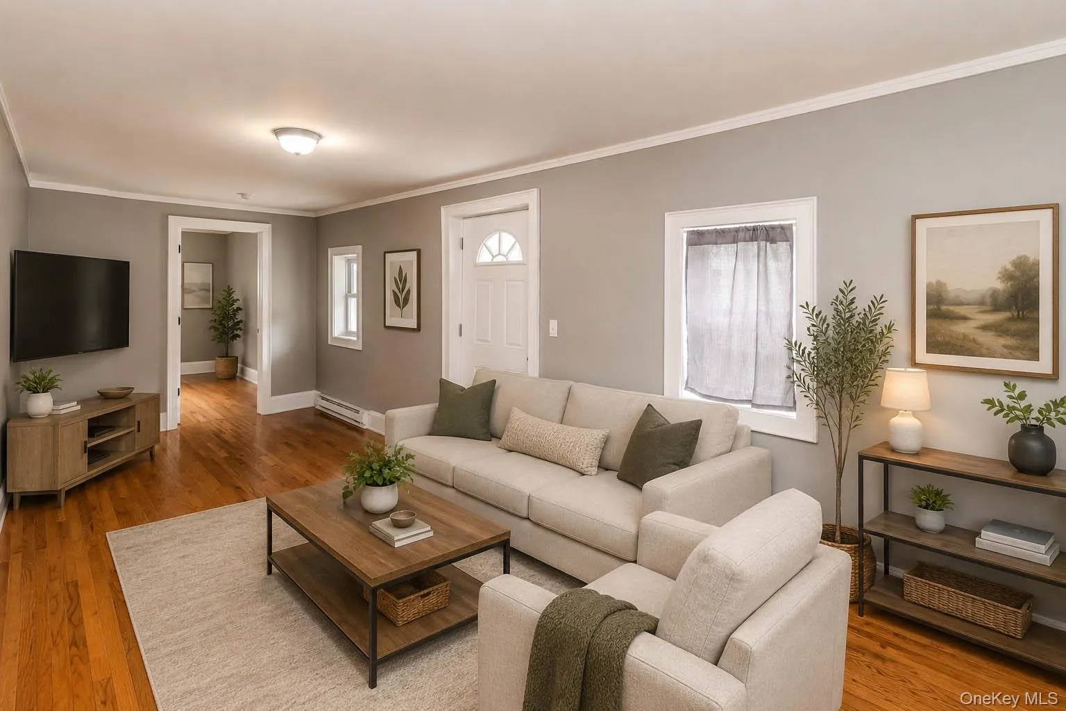 Hardwood flooring throughout, crown molding, white trim, and a white paneled front door with decorative glass Hardwood flooring throughout, crown molding, white trim, and a white paneled front door with decorative glass