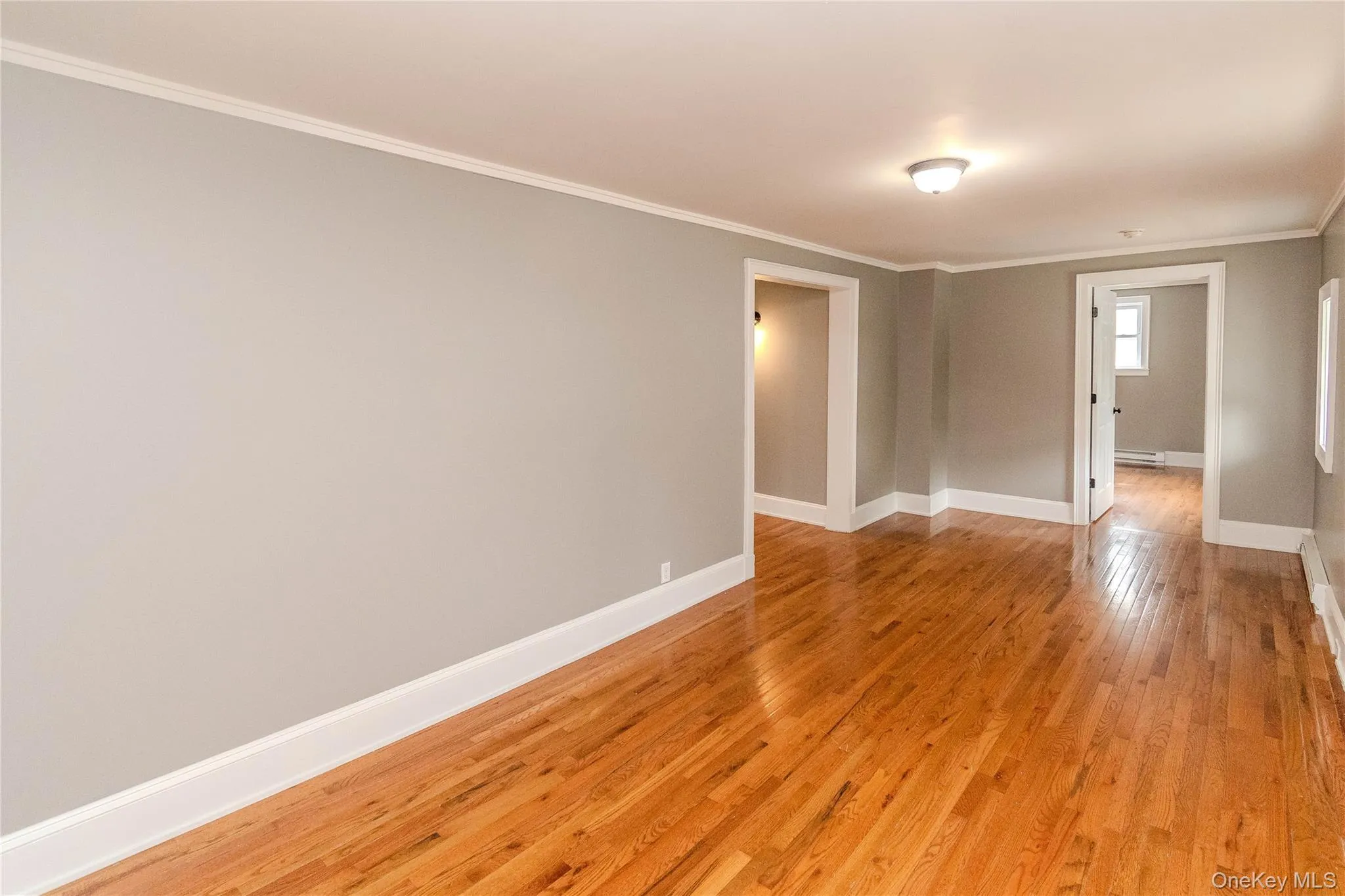 Hardwood flooring, light gray wall paint, white trim, recessed lighting, and white paneled doors Hardwood flooring, light gray wall paint, white trim, recessed lighting, and white paneled doors