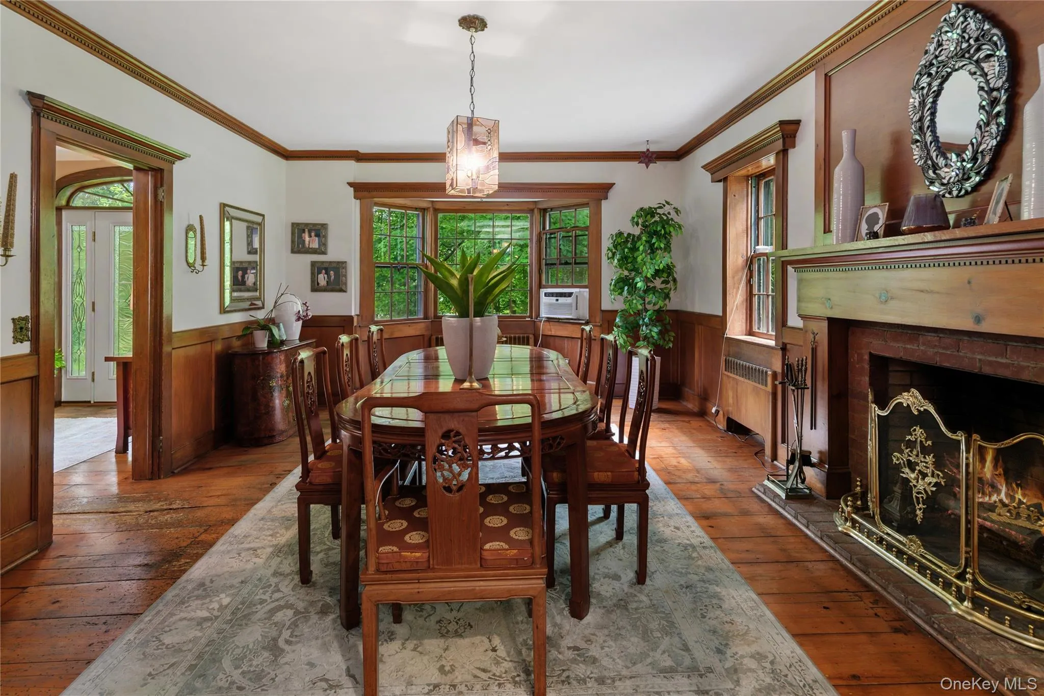 Formal dining room with bay window, wide board vintage wood floors, fireplace, crown molding, chair rail and wall paneling Formal dining room with bay window, wide board vintage wood floors, fireplace, crown molding, chair rail and wall paneling