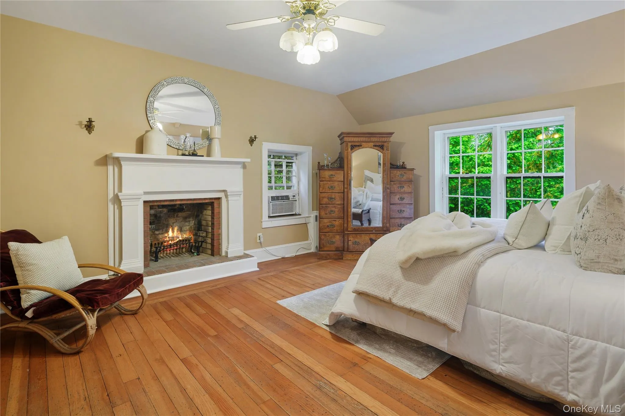 Primary bedroom with pine floors, fireplace, ceiling fan, ensuite primary bath, large walk-in closet Primary bedroom with pine floors, fireplace, ceiling fan, ensuite primary bath, large walk-in closet
