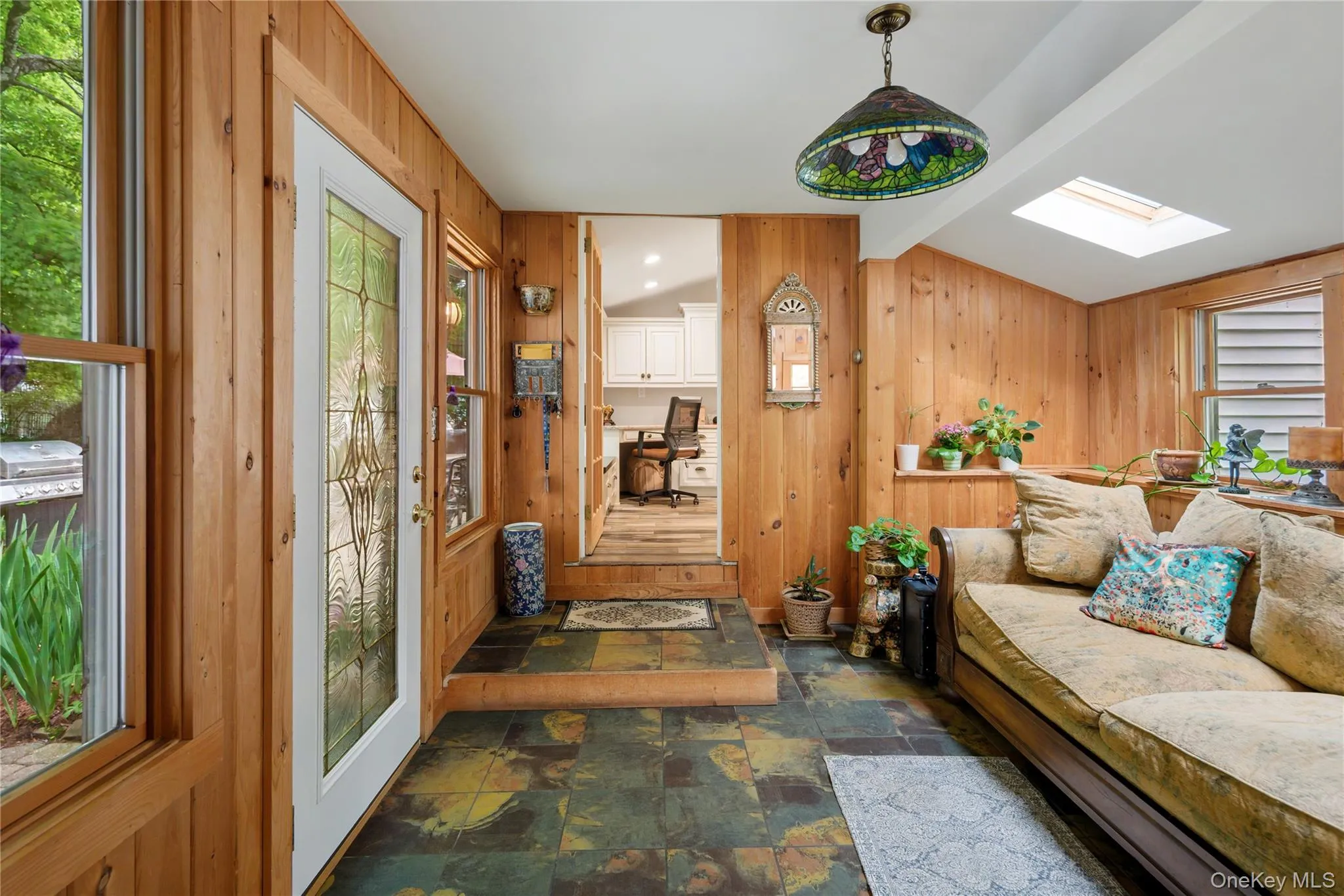 Rear entry hall with leaded glass door, tile floor, skylight, tongue and groove cedar paneling, tiffany style fixture, doorway to kitchen, doorway to professional office suite (not shown) Rear entry hall with leaded glass door, tile floor, skylight, tongue and groove cedar paneling, tiffany style fixture, doorway to kitchen, doorway to professional office suite (not shown)
