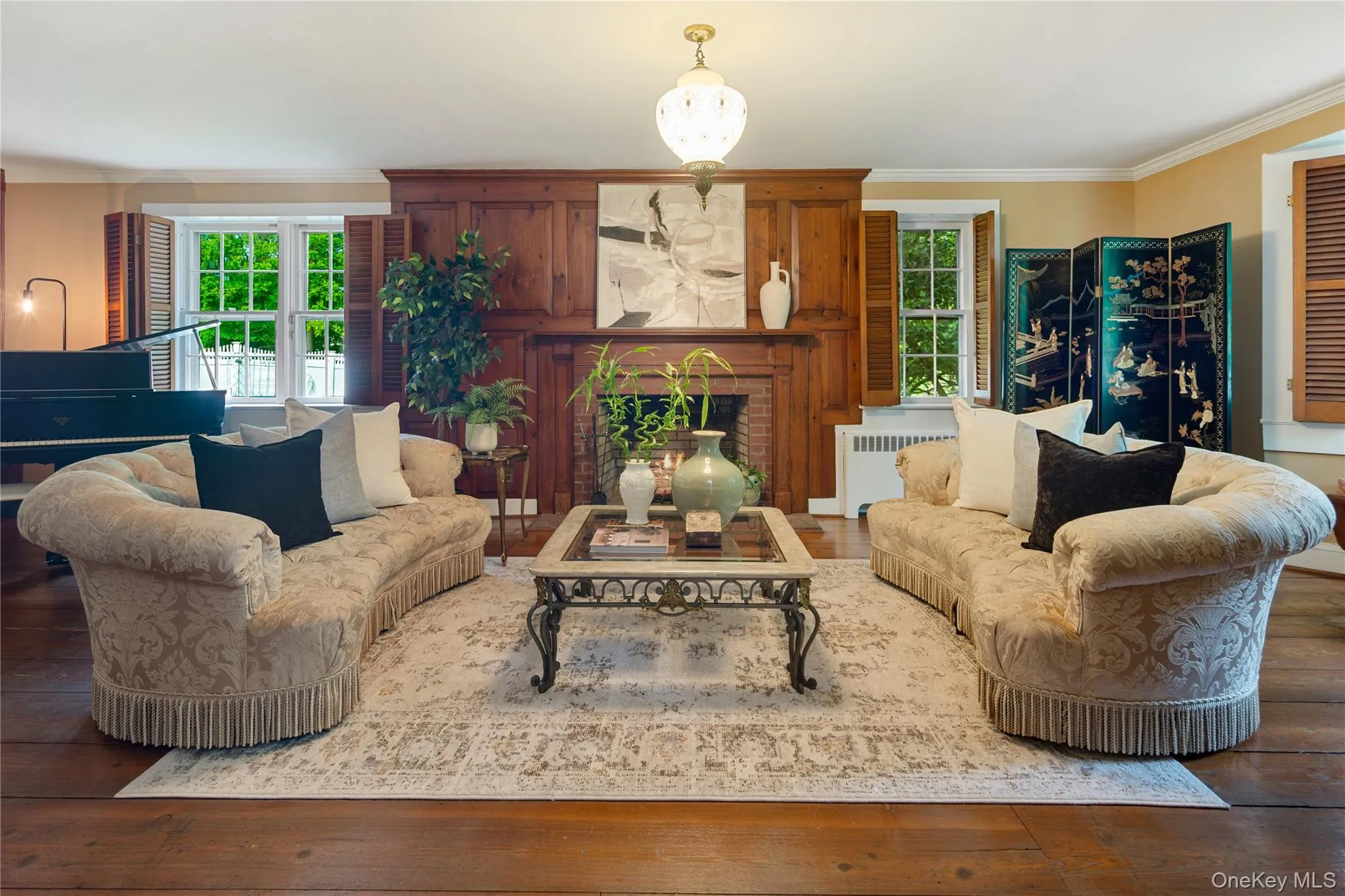 Gracious size formal living room with fireplace with wood paneled surround, crown molding, built-in bookcases with cabinets below, wide board vintage wood floors Gracious size formal living room with fireplace with wood paneled surround, crown molding, built-in bookcases with cabinets below, wide board vintage wood floors
