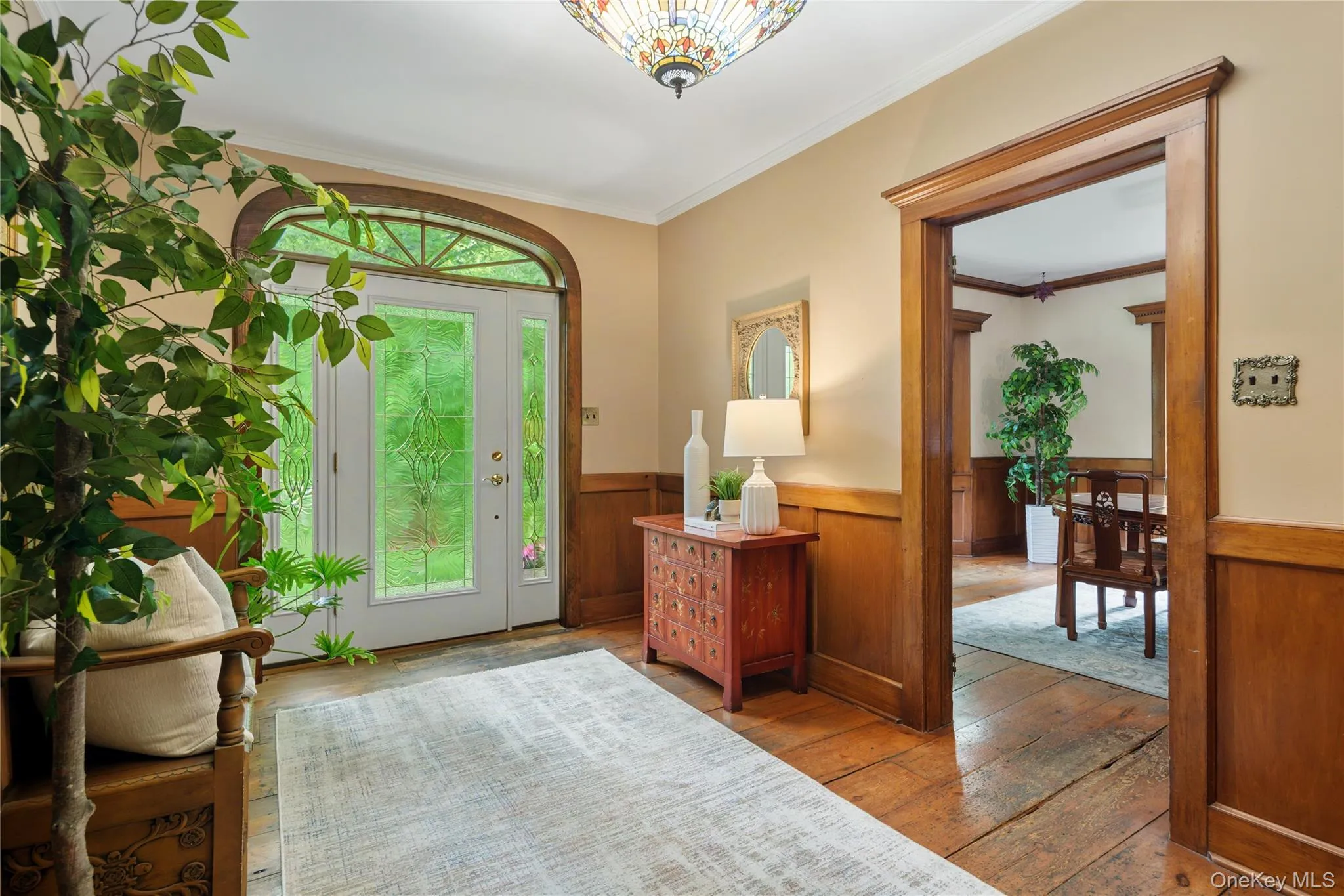 Front entry with leaded glass door, sidelights, demilune transom window, wide board vintage floors, chair rail, paneling, Tiffany style light fixture Front entry with leaded glass door, sidelights, demilune transom window, wide board vintage floors, chair rail, paneling, Tiffany style light fixture