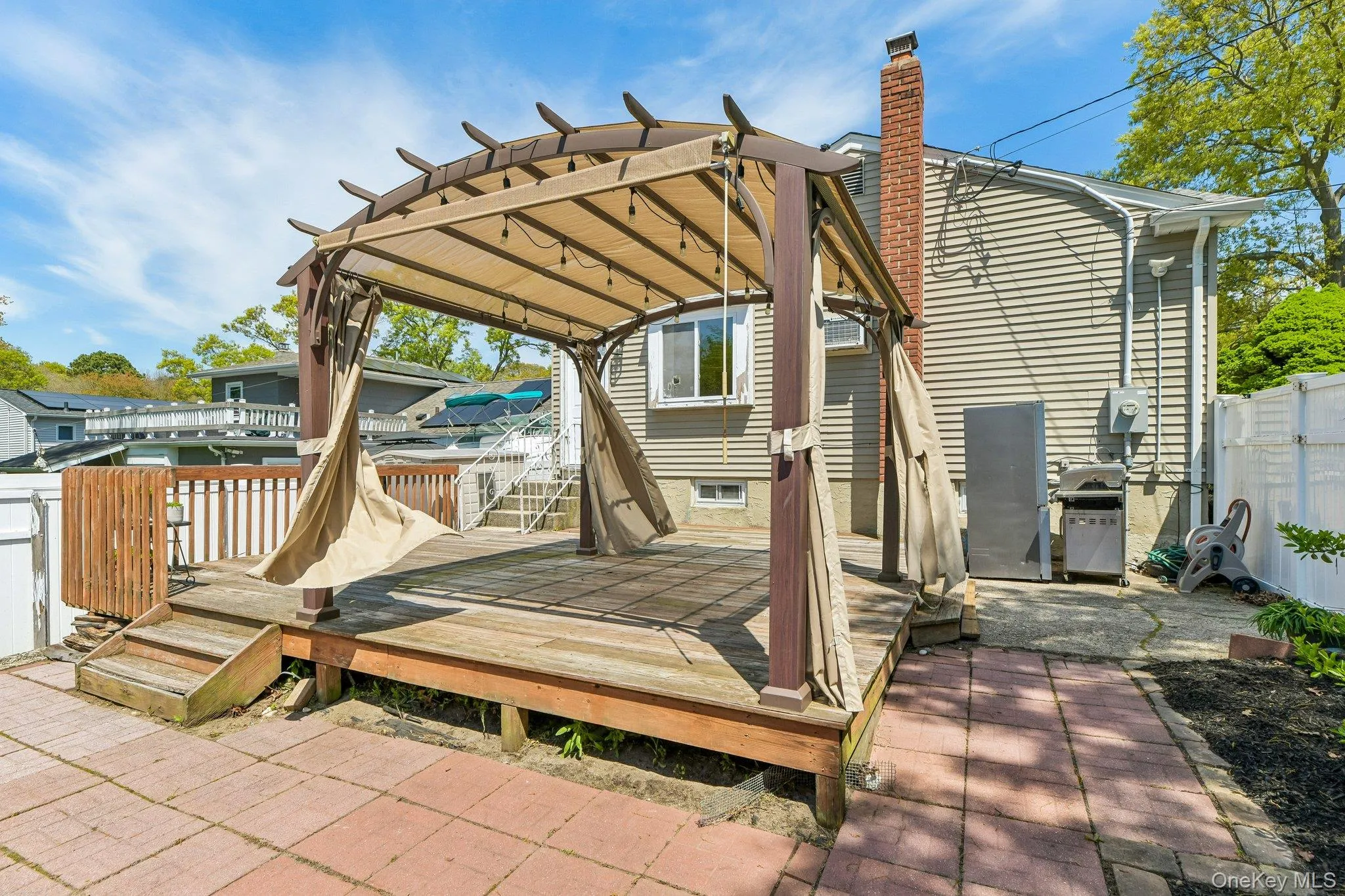 Expansive wood deck with a built-in pergola, offering a dedicated outdoor living space Expansive wood deck with a built-in pergola, offering a dedicated outdoor living space