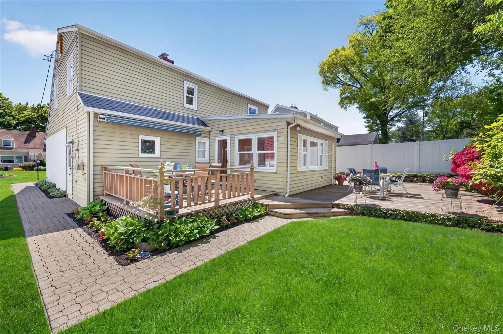 Expansive backyard featuring a lush lawn, a multi-level deck, and a paver patio. Expansive backyard featuring a lush lawn, a multi-level deck, and a paver patio.