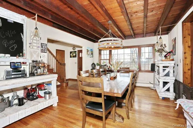 Dining area featuring stairway, wood ceiling, beam ceiling, and wood finished floors Dining area featuring stairway, wood ceiling, beam ceiling, and wood finished floors