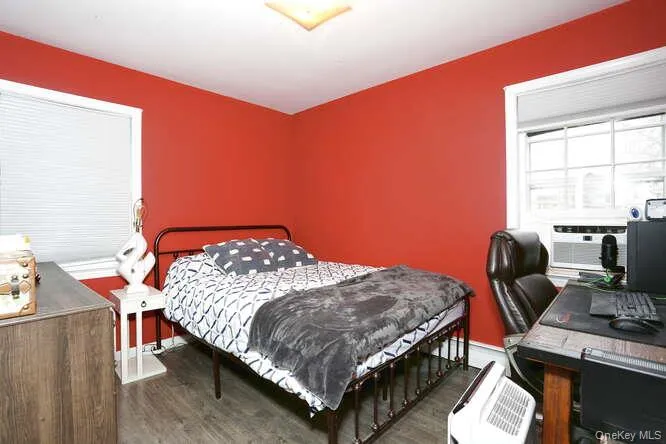 Bedroom featuring cooling unit and wood finished floors Bedroom featuring cooling unit and wood finished floors
