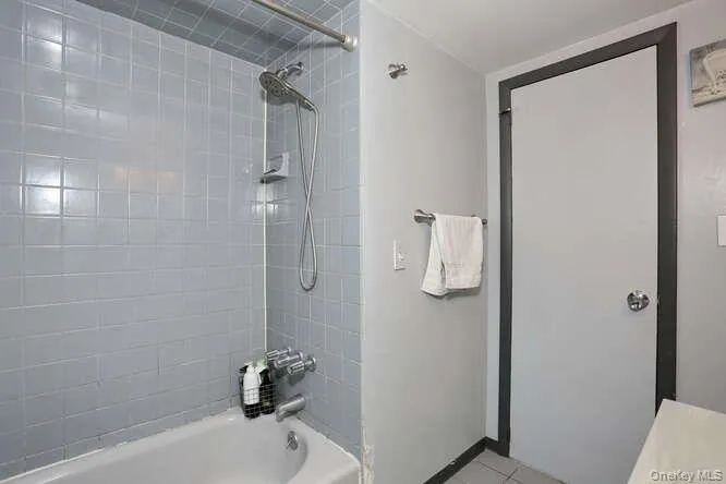 Full bath featuring tile patterned floors and shower / bath combination Full bath featuring tile patterned floors and shower / bath combination