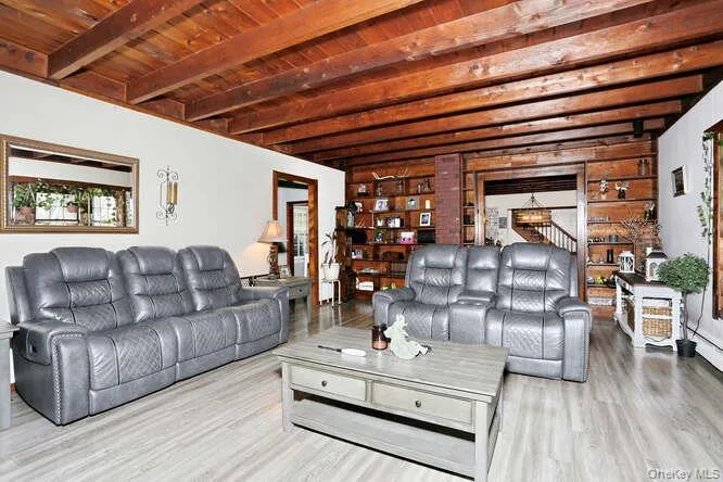Living area with stairway, wood ceiling, beam ceiling, and wood finished floors Living area with stairway, wood ceiling, beam ceiling, and wood finished floors