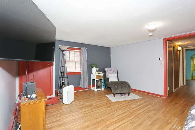 Living area with light wood-type flooring and baseboards Living area with light wood-type flooring and baseboards
