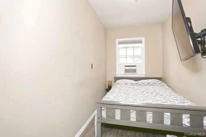 Bedroom with cooling unit and baseboards Bedroom with cooling unit and baseboards