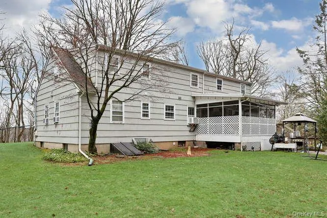 Back of house featuring a yard, a gazebo, and a sunroom Back of house featuring a yard, a gazebo, and a sunroom