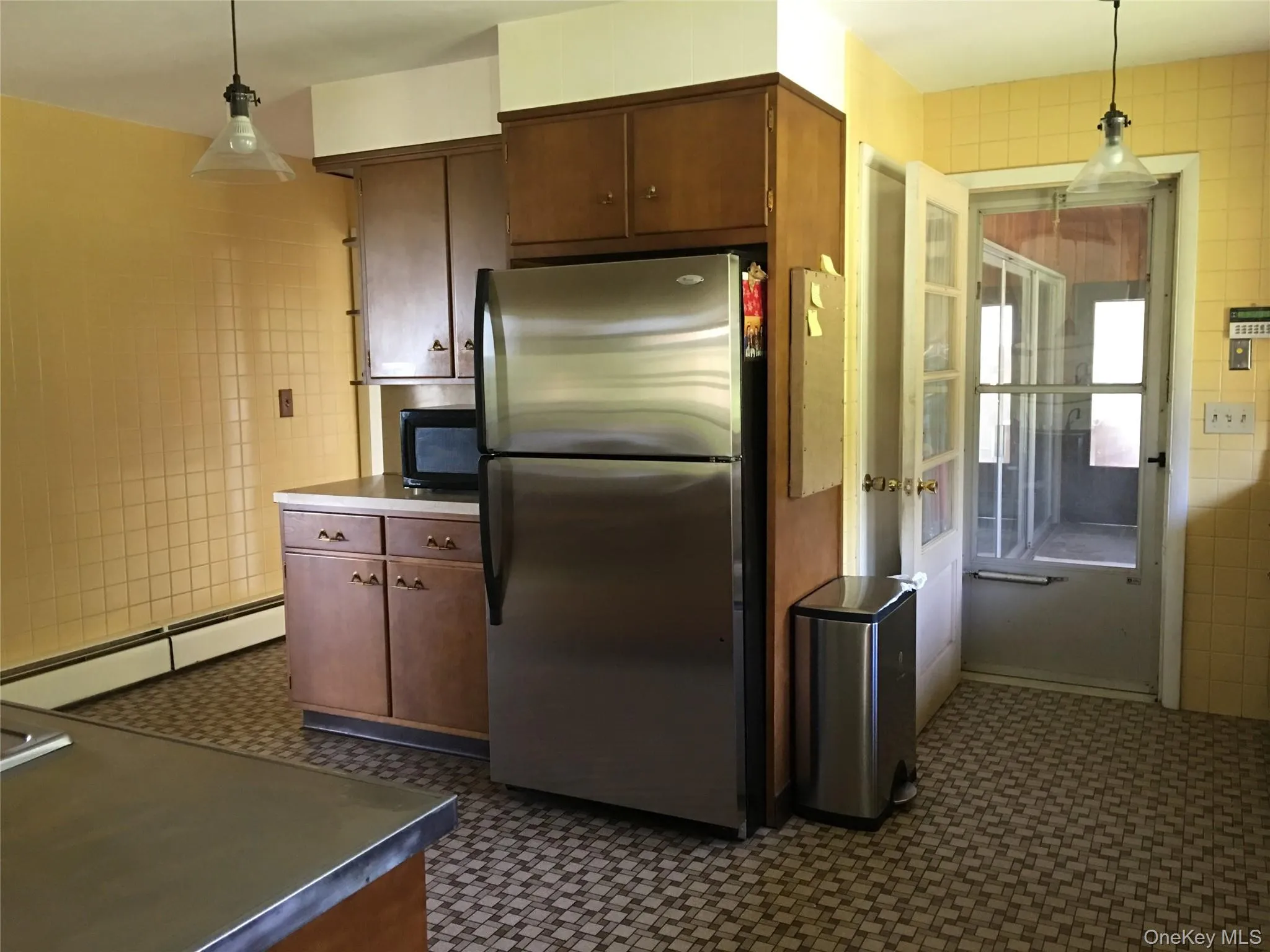Kitchen with refrigerator, with access to hobby room on left and mudroom on right Kitchen with refrigerator, with access to hobby room on left and mudroom on right