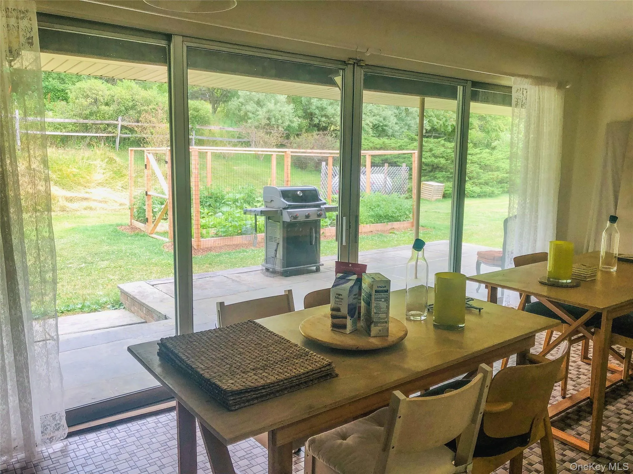 Dining room with sliding doors to covered patio, yard and vegetable garden Dining room with sliding doors to covered patio, yard and vegetable garden
