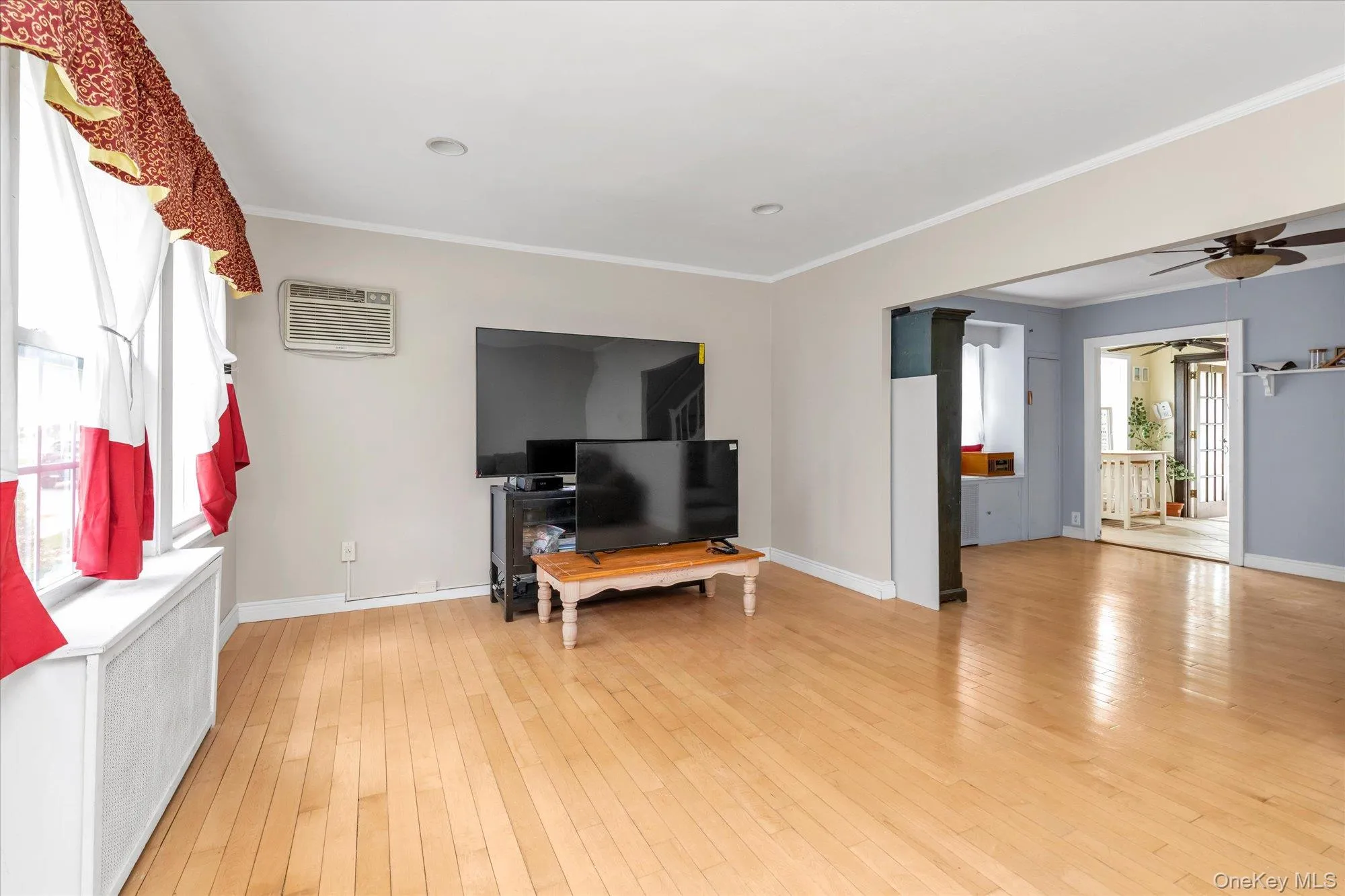 Entry area with wood-finish flooring, light neutral wall paint, and a bright white oval-lite entry door Entry area with wood-finish flooring, light neutral wall paint, and a bright white oval-lite entry door
