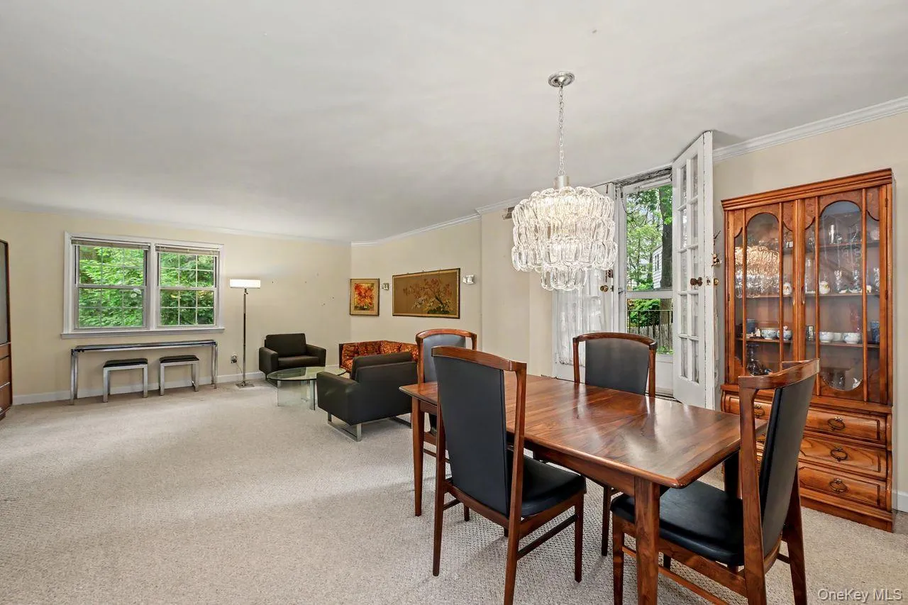 View from dining area into living room. Solid wood floors underneath carpet View from dining area into living room. Solid wood floors underneath carpet