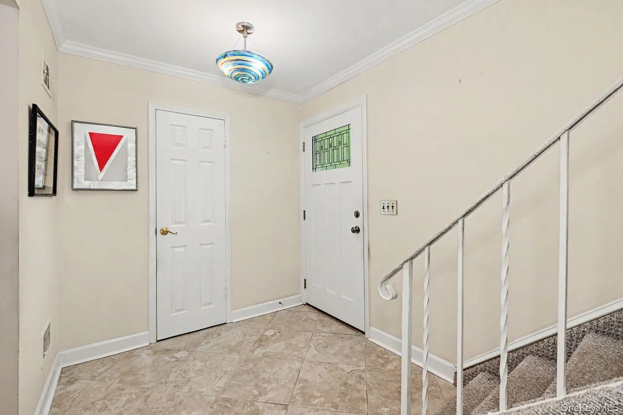 Tiled entry foyer shows door to bathroom Tiled entry foyer shows door to bathroom