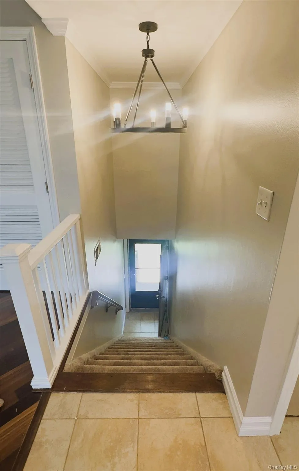 Top view of stairs case, chandelier, wooden railing, crown molding. Top view of stairs case, chandelier, wooden railing, crown molding.