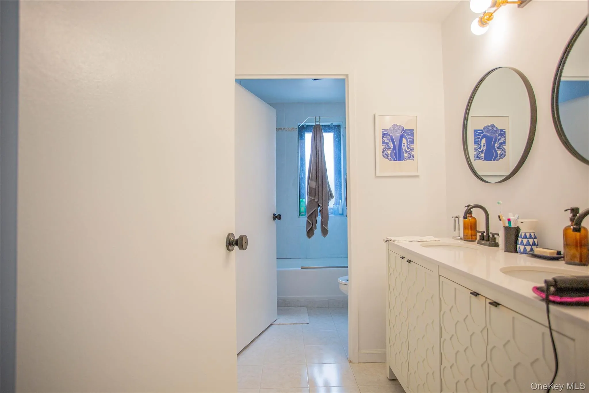 Full bath with a sink, tile patterned flooring, toilet, and double vanity Full bath with a sink, tile patterned flooring, toilet, and double vanity