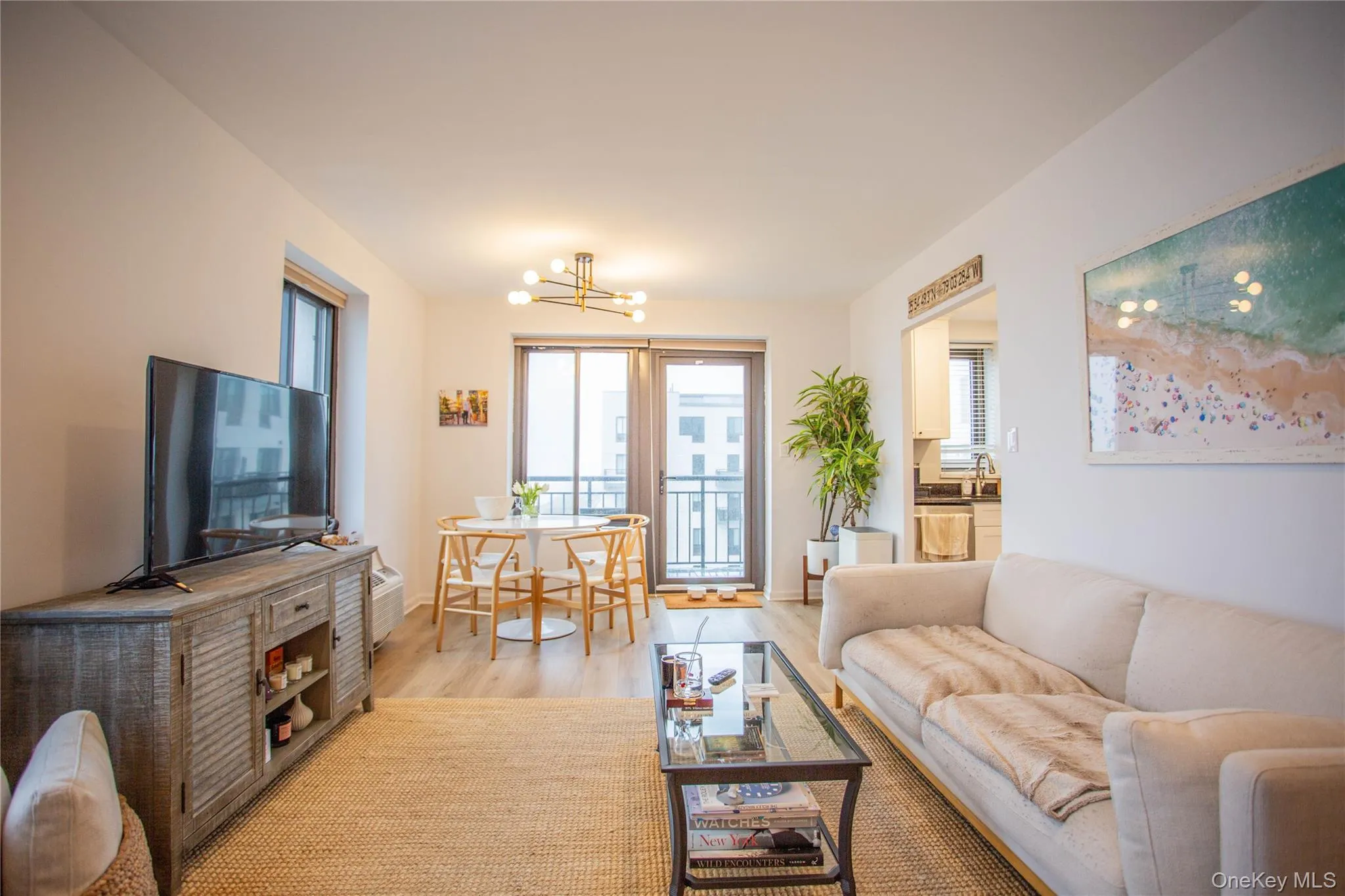Living room with an inviting chandelier, baseboards, and light wood-style floors Living room with an inviting chandelier, baseboards, and light wood-style floors