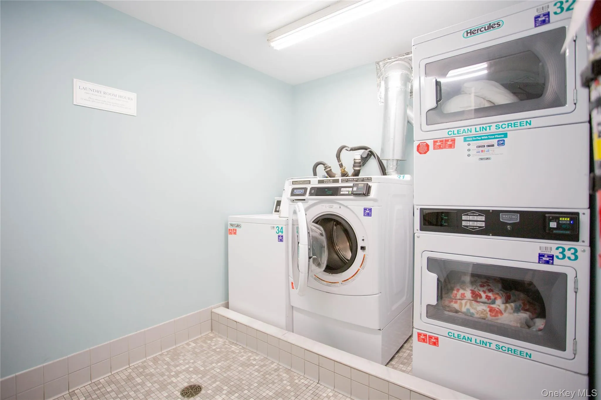 Shared laundry area with tile patterned floors and washing machine and dryer Shared laundry area with tile patterned floors and washing machine and dryer