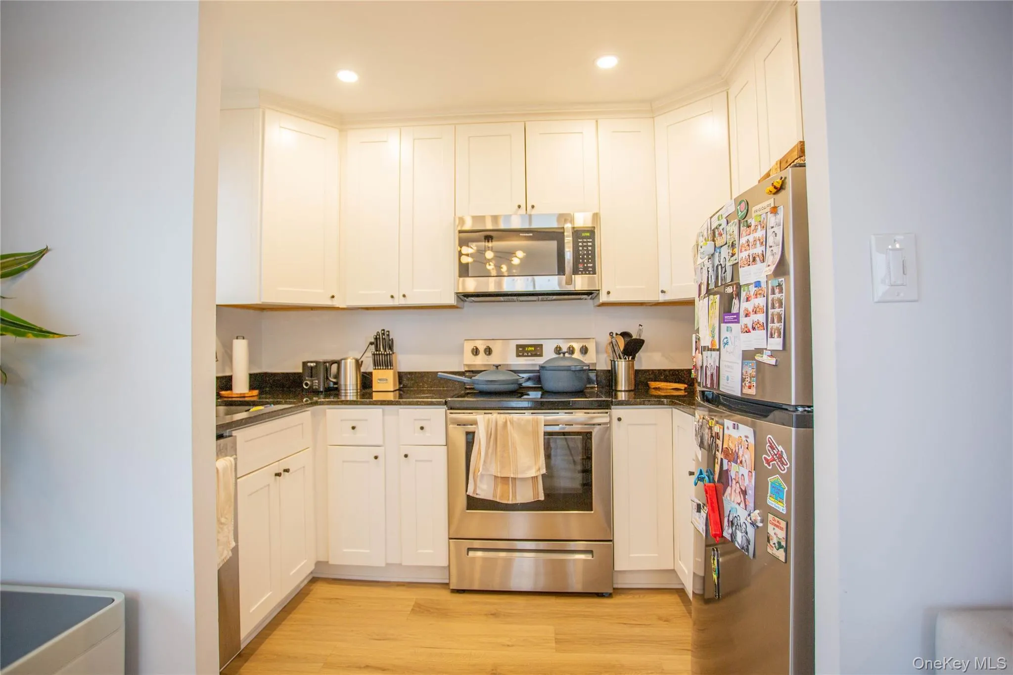 Kitchen with white cabinets, appliances with stainless steel finishes, and light wood-type flooring Kitchen with white cabinets, appliances with stainless steel finishes, and light wood-type flooring