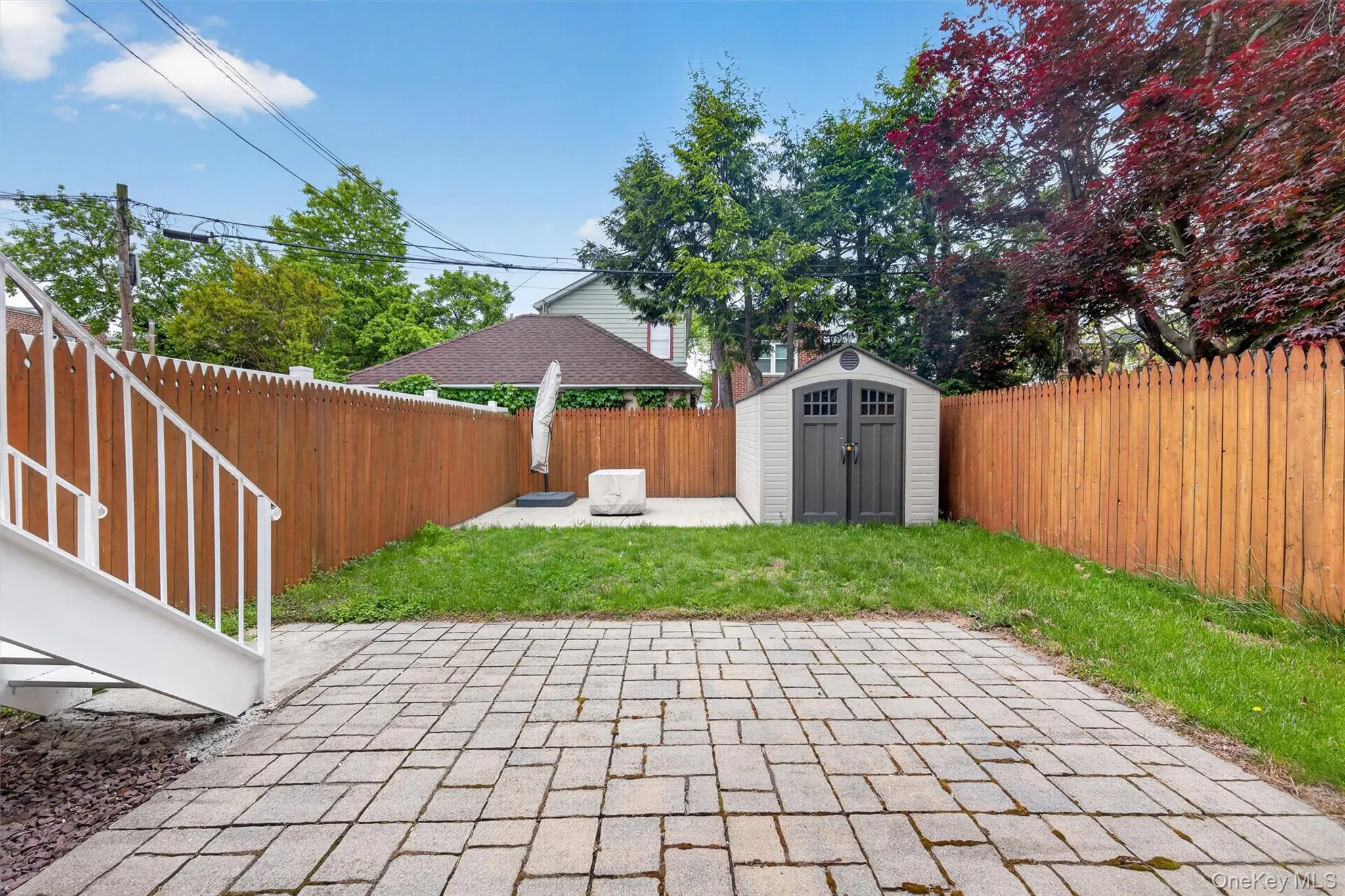 Backyard, pavers, grassy area and shed Backyard, pavers, grassy area and shed