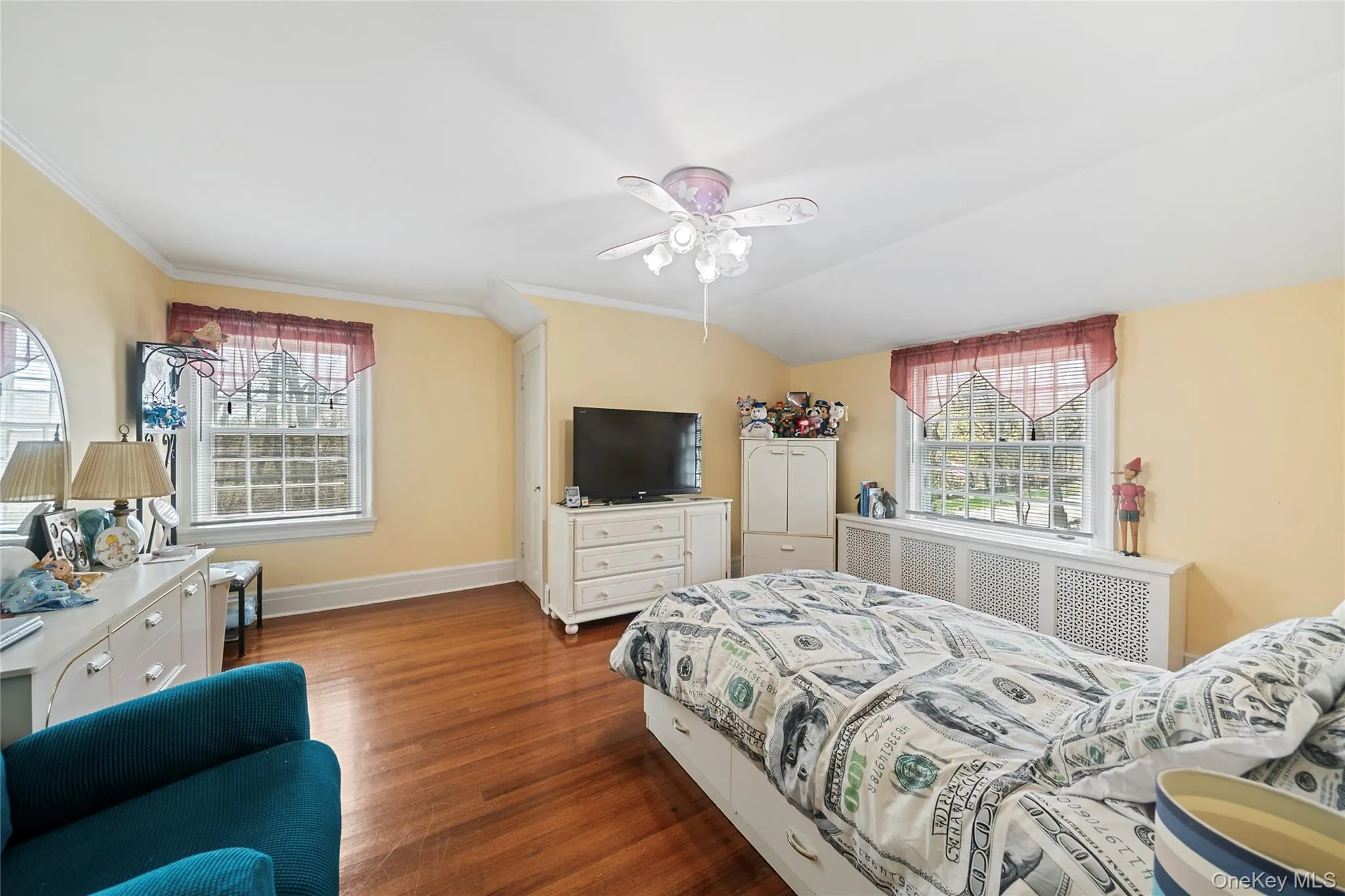 Interior room featuring wood-finish flooring, two large windows with mullions, and a ceiling fan with integrated lighting Interior room featuring wood-finish flooring, two large windows with mullions, and a ceiling fan with integrated lighting