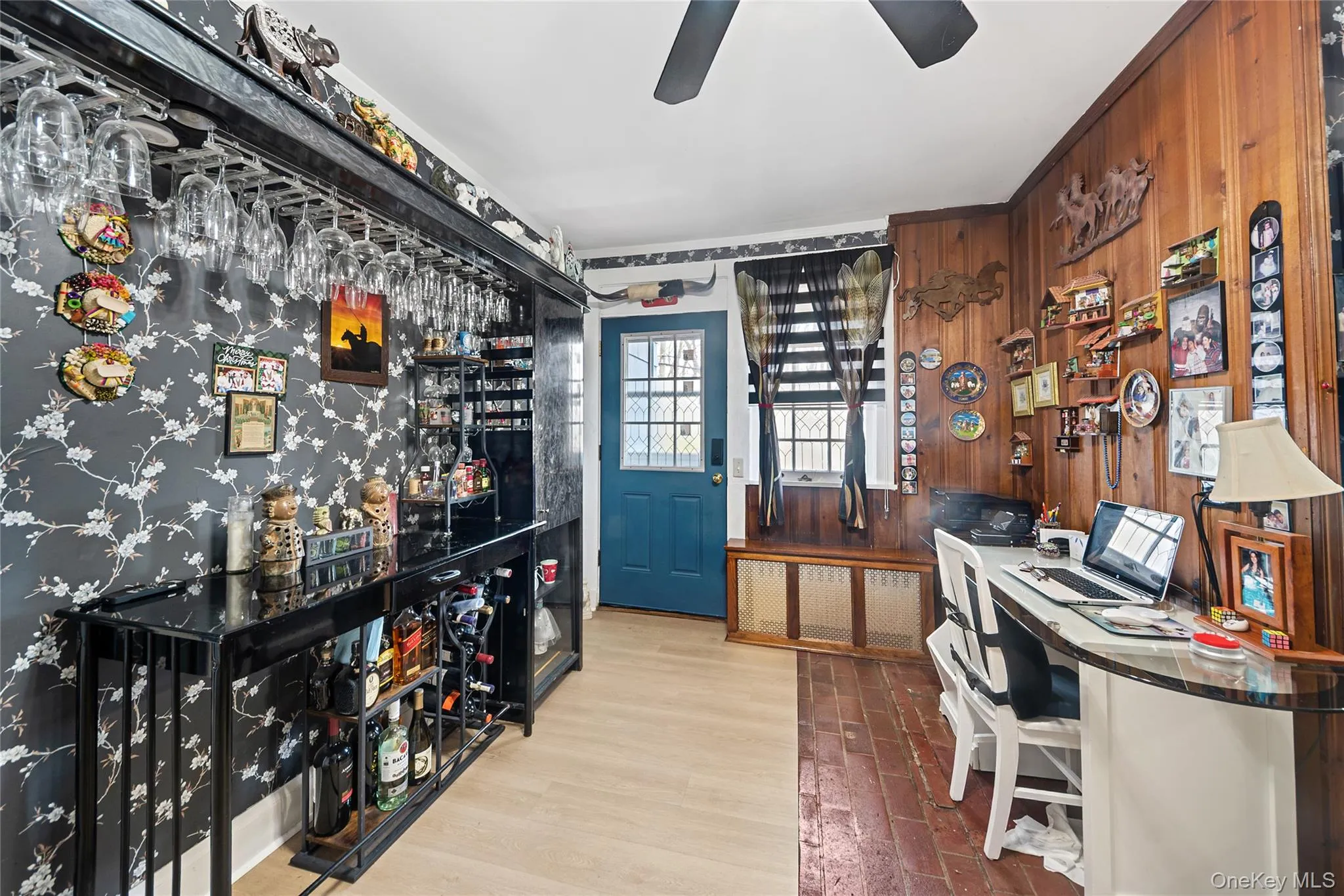 Dedicated entertainment space featuring a built-in bar with glass shelving and integrated wine storage Dedicated entertainment space featuring a built-in bar with glass shelving and integrated wine storage