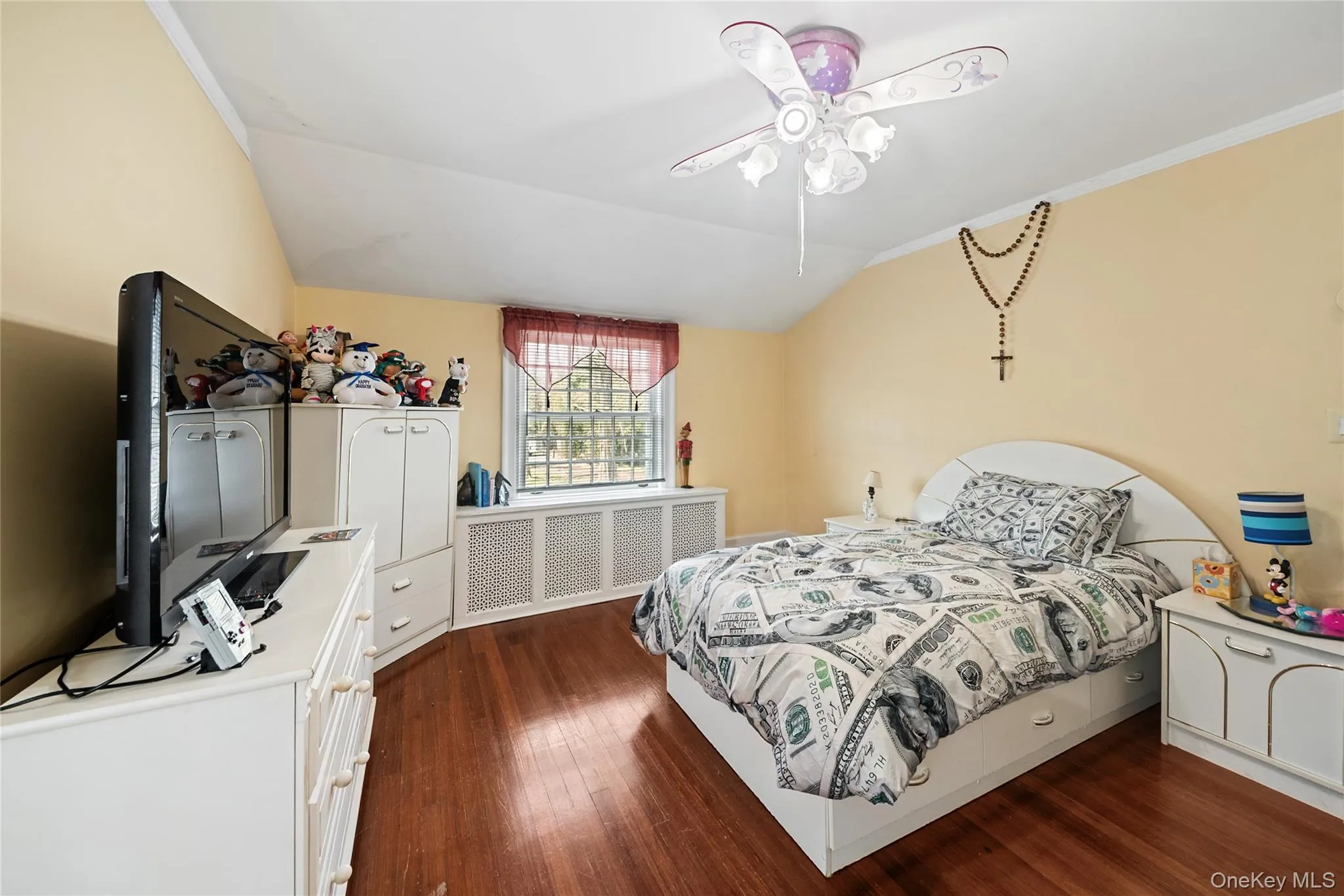 Bedroom featuring wood-finish flooring, a window with decorative security bars, and a ceiling fan with integrated lighting Bedroom featuring wood-finish flooring, a window with decorative security bars, and a ceiling fan with integrated lighting