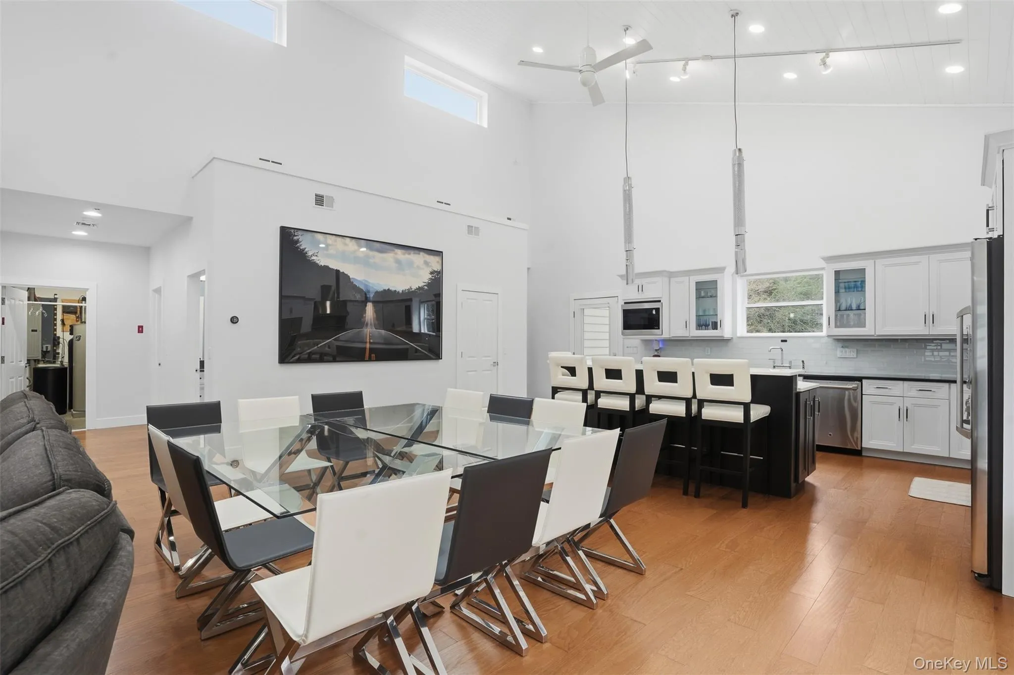 Open-concept living space featuring high vaulted ceilings and light wood-finish flooring Open-concept living space featuring high vaulted ceilings and light wood-finish flooring