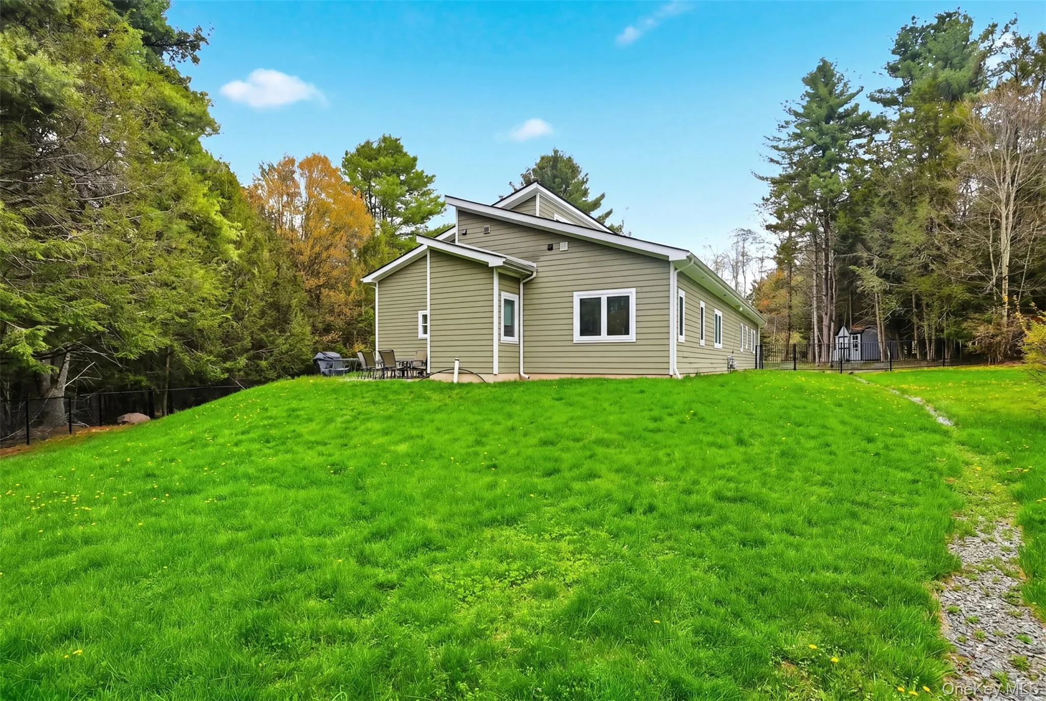 Modern-style exterior with olive green siding, white trim, and multiple windows Modern-style exterior with olive green siding, white trim, and multiple windows